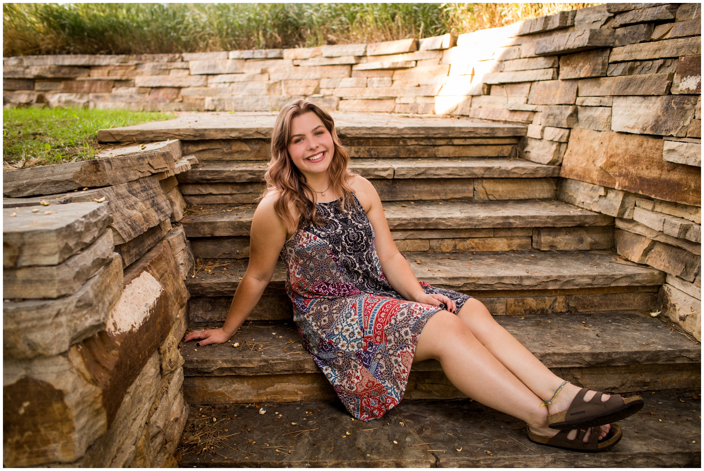 teen sitting on stone steps during Longmont senior photography session at Sandstone Ranch