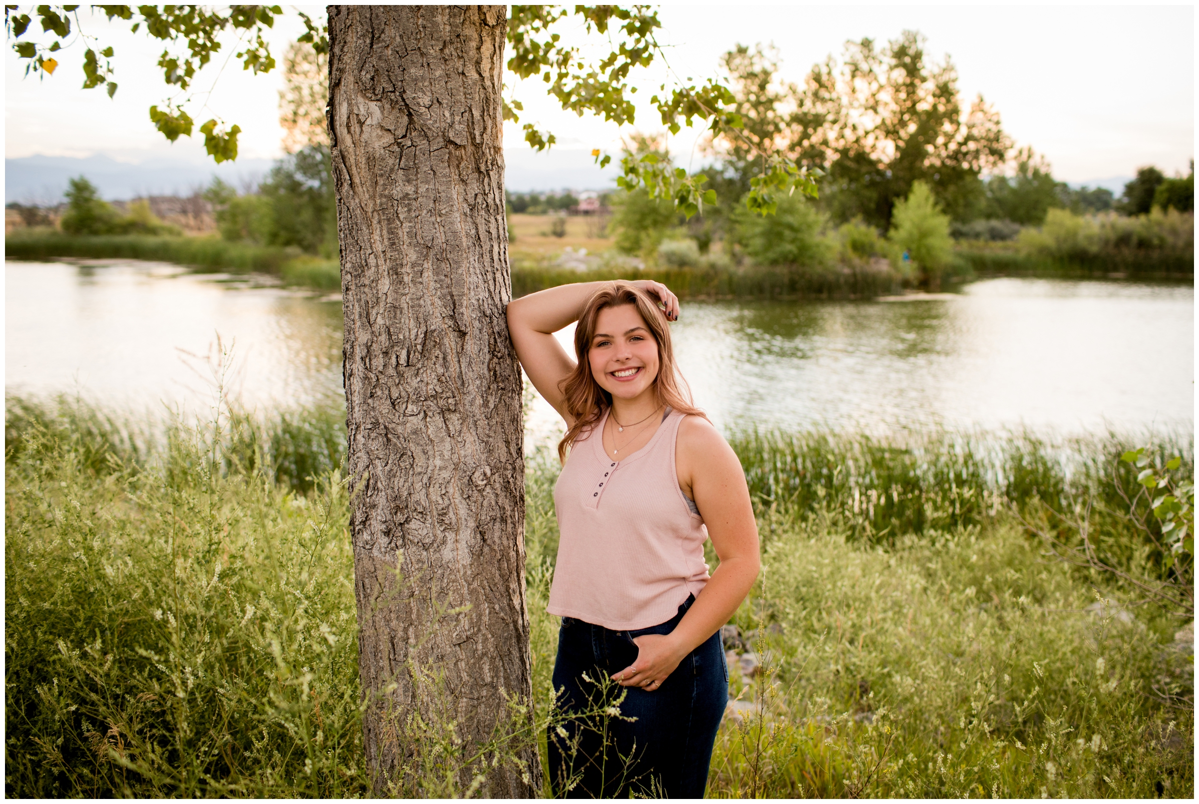 teen girl leaning against tree during Colorado lake senior pictures 