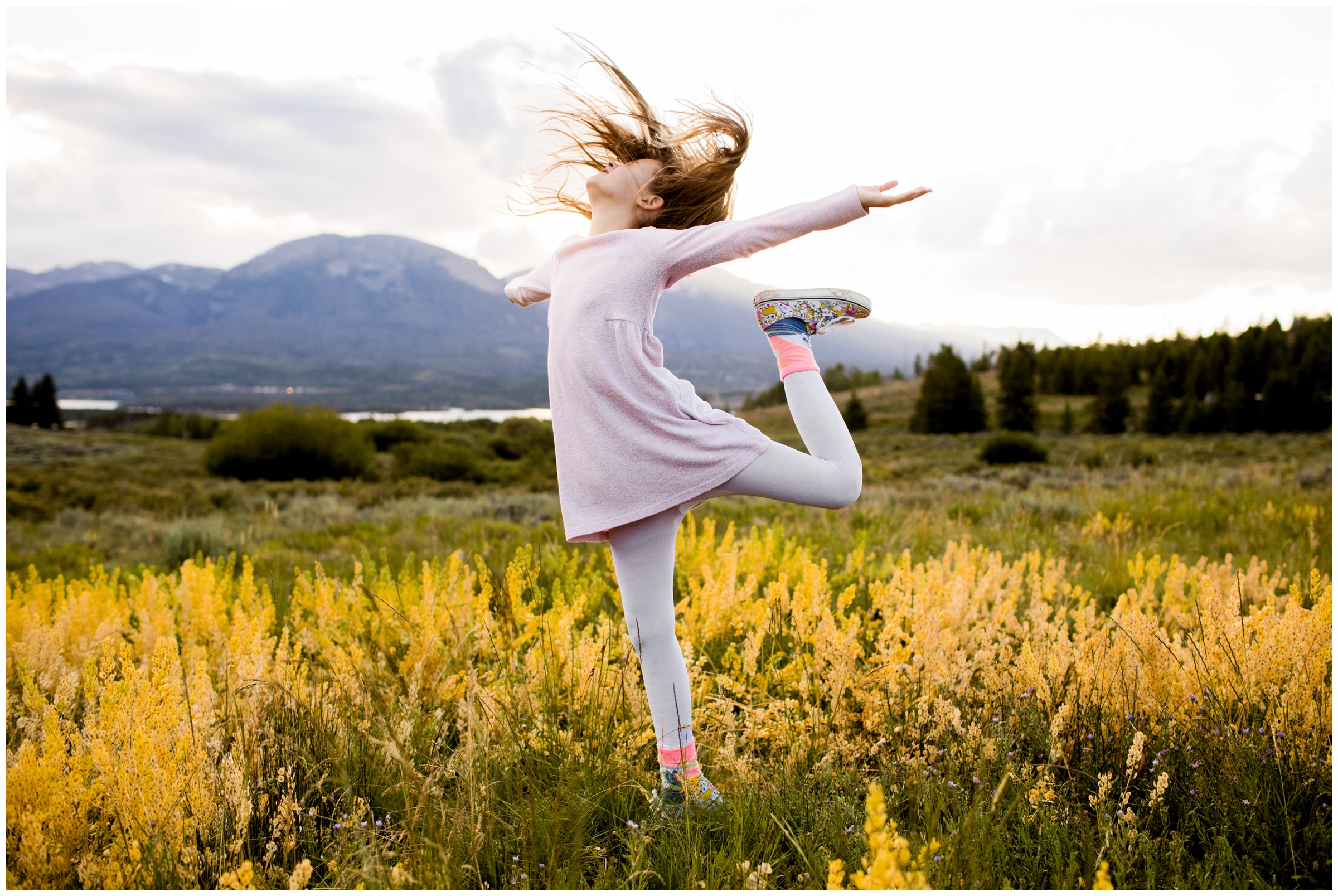 Girl dancing in field during Colorado mountain family photos in Breckenridge