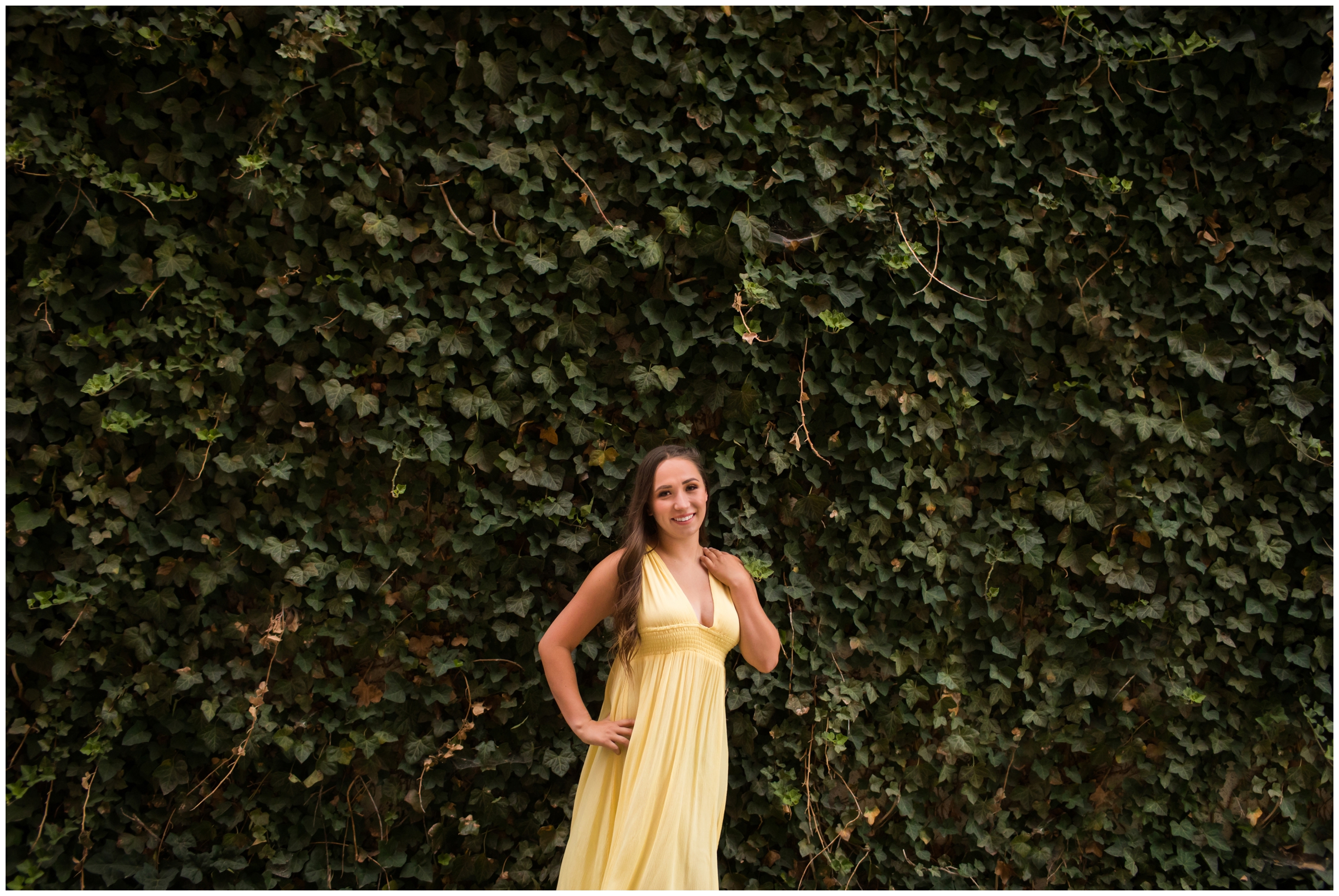 teen posing in front of ivy wall during Colorado graduation portraits 