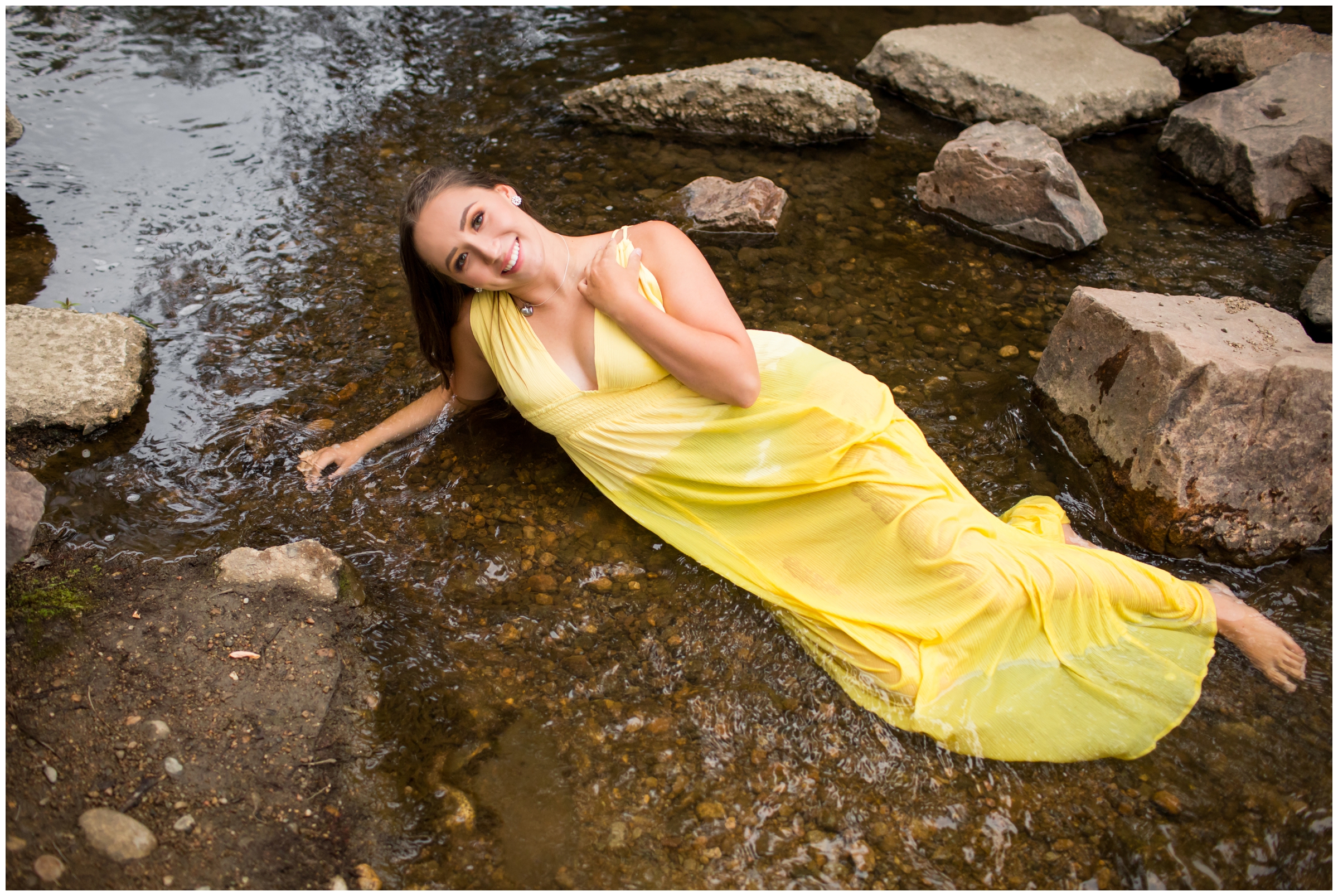 teen girl laying in river during Colorado mountain senior portraits 