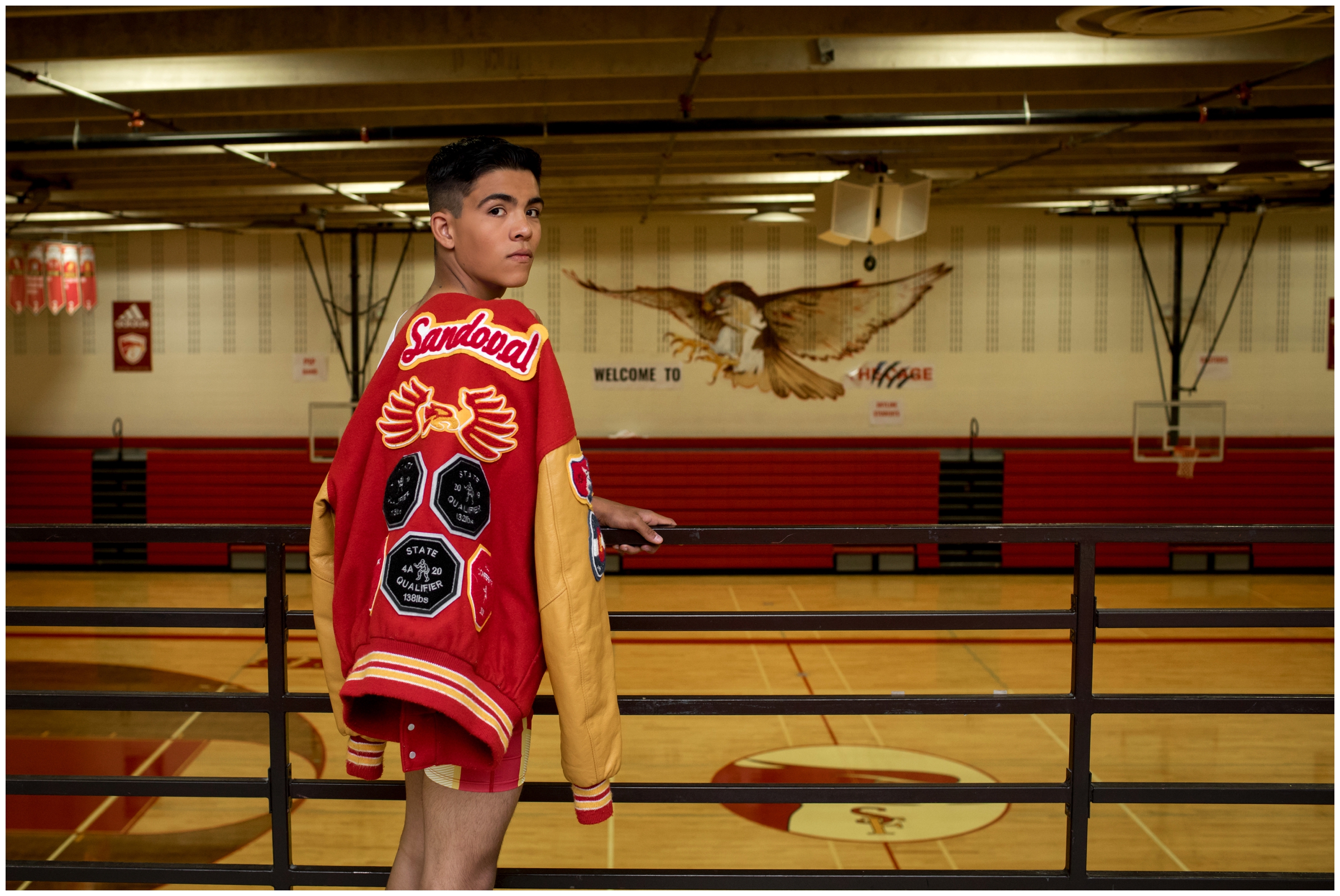 teen boy in letterman jacket at Skyline High School senior portraits