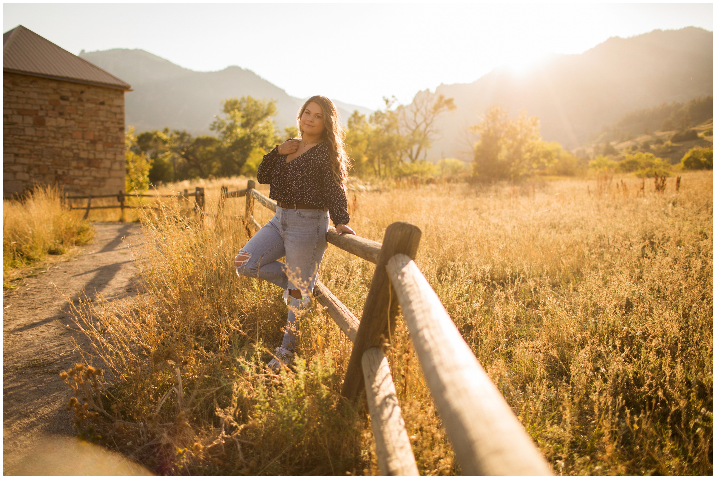 teen leaning on fence during mountain senior pictures at Boulder flatirons 