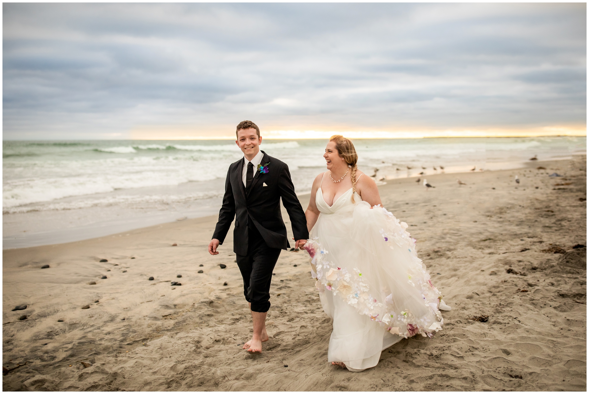 couple walking along beach at Oceanside Pier during Carlsbad destination wedding photography