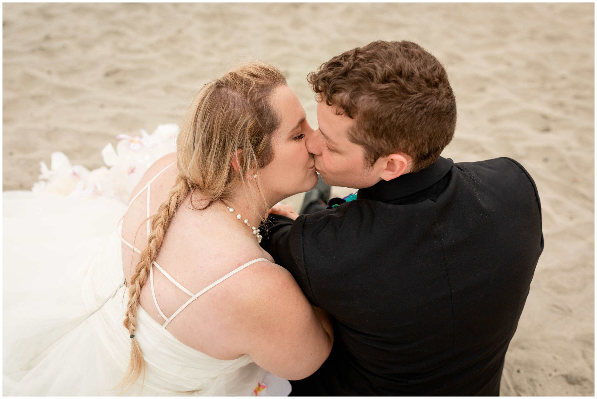 couple sitting in the sand during California newlywed wedding portraits 