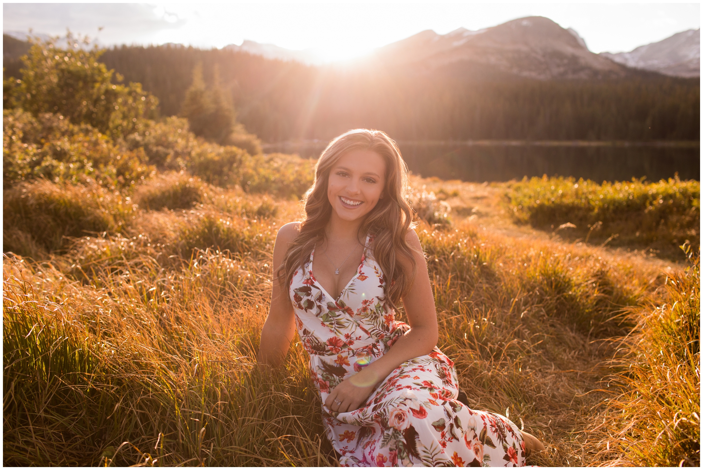 teen girl sitting in golden field during Colorado senior pictures 