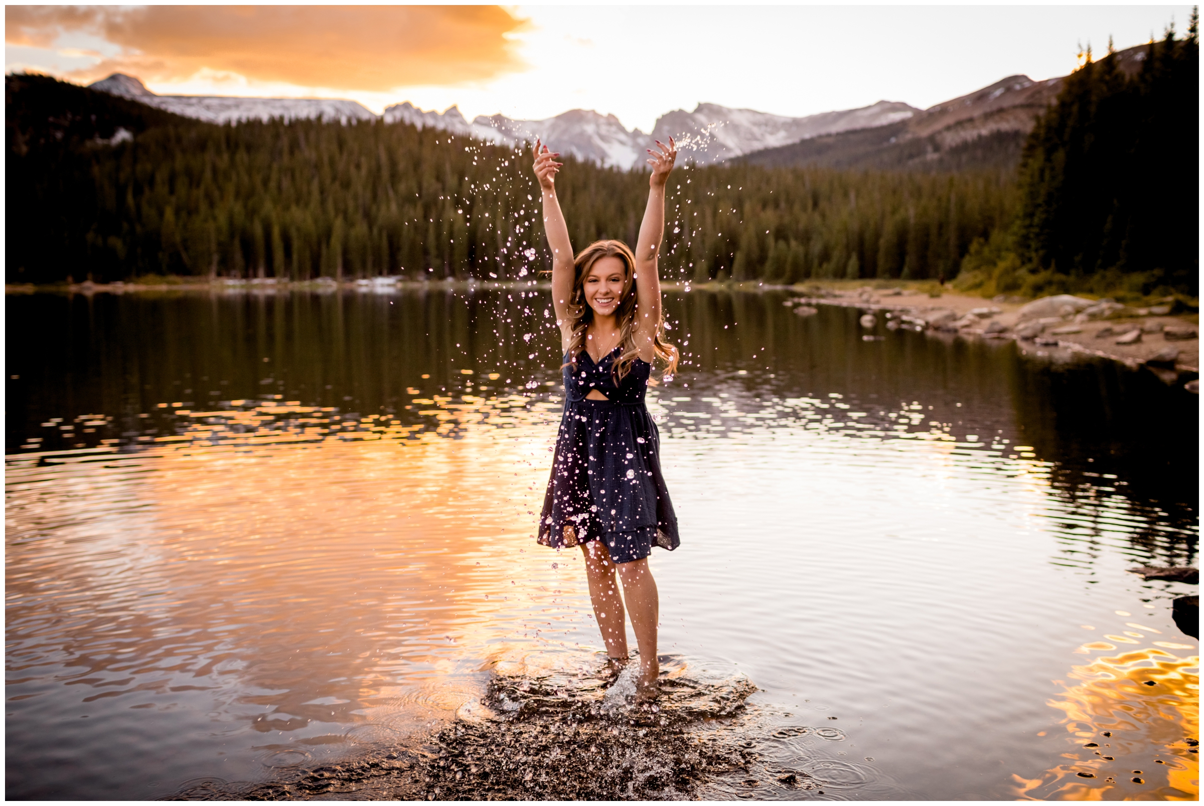 girl throwing water during Colorado mountain lake senior photography session 