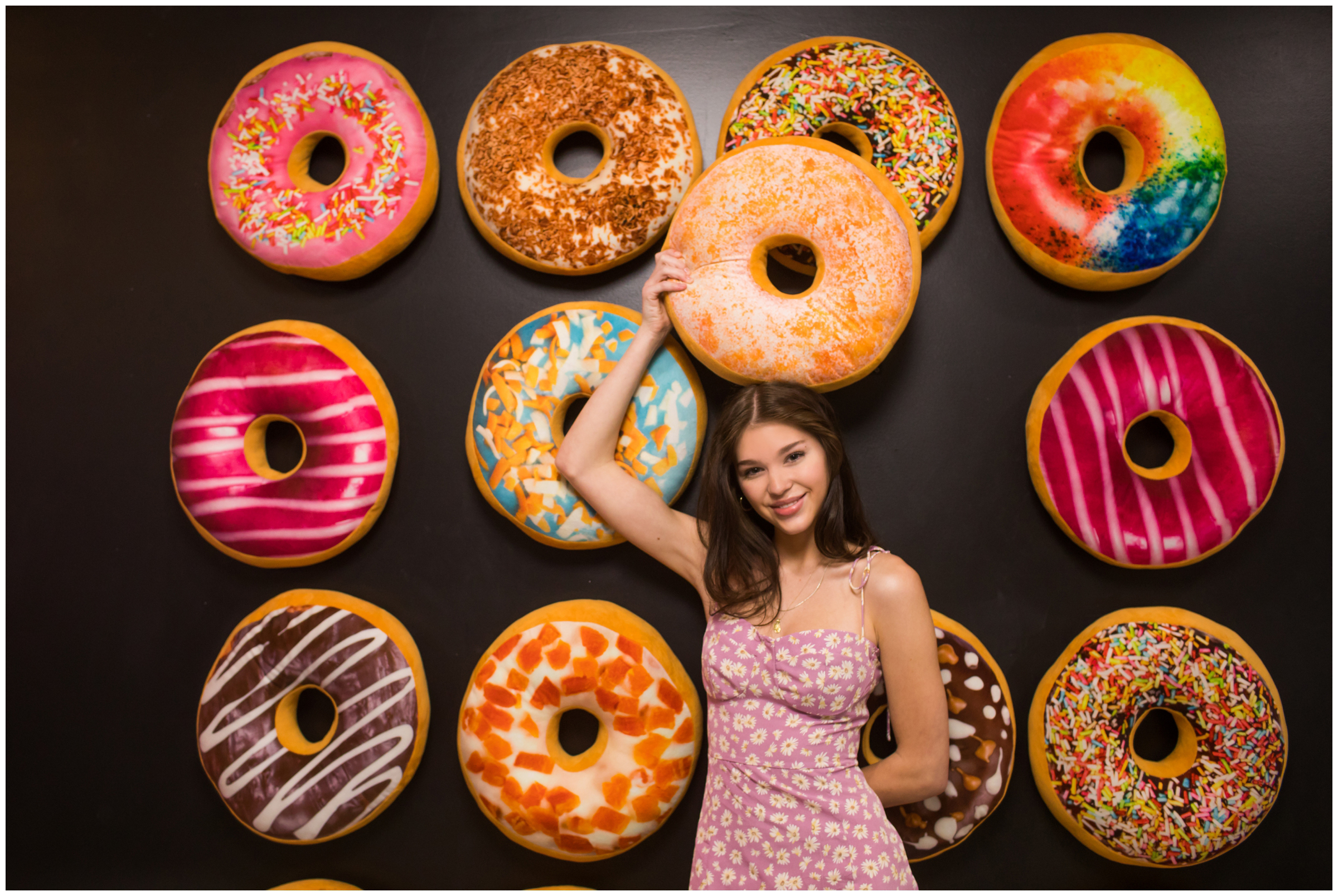 teen posing against donut wall during Denver Selfie Museum Colorado senior photos 