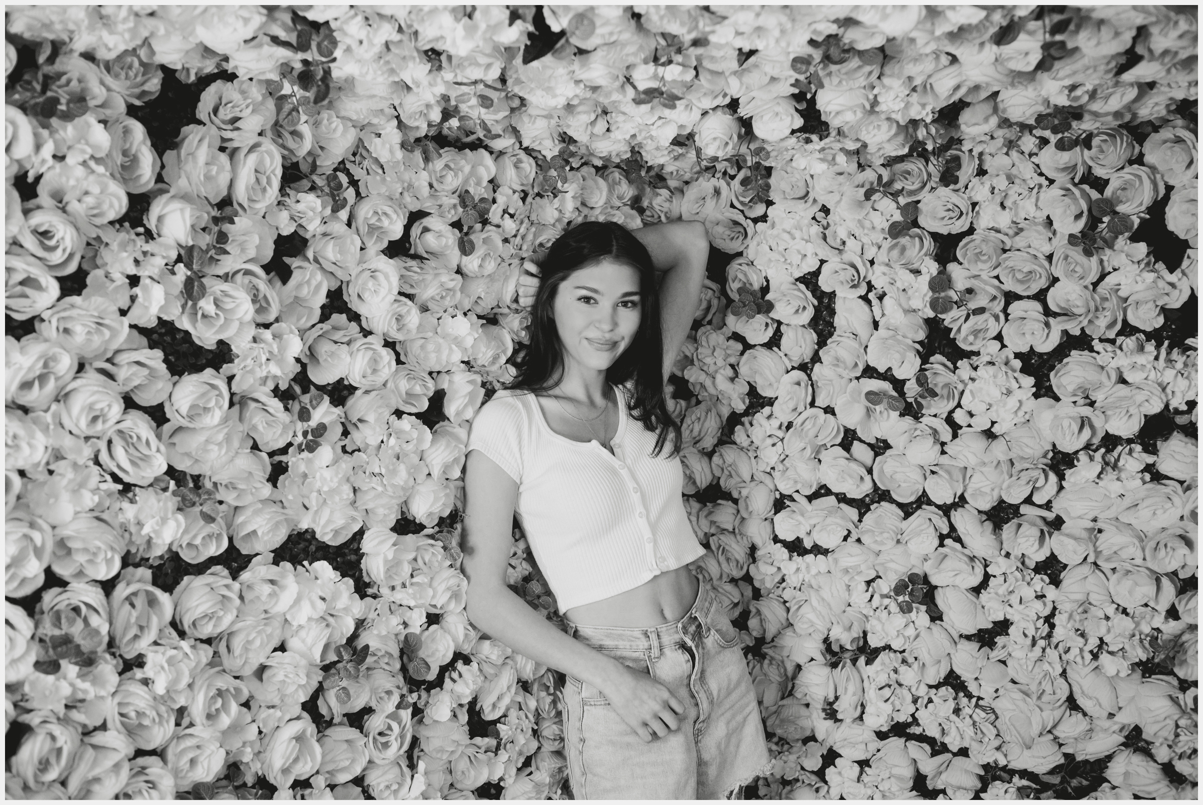 teen girl posing against floral wall during Denver Selfie Museum senior pictures by Plum Pretty Photo 