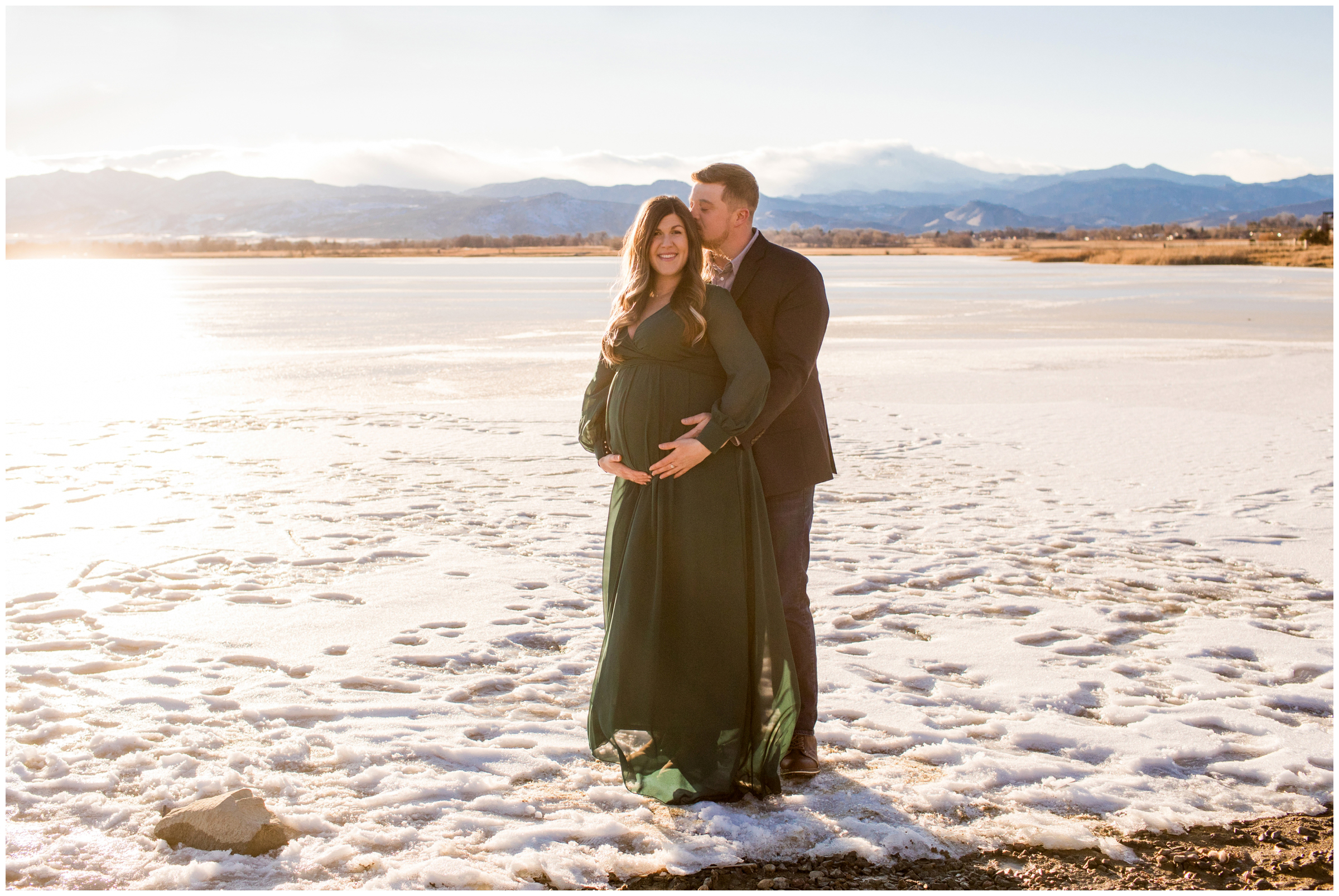 couple posing on frozen lake during Colorado winter pregnancy photos 