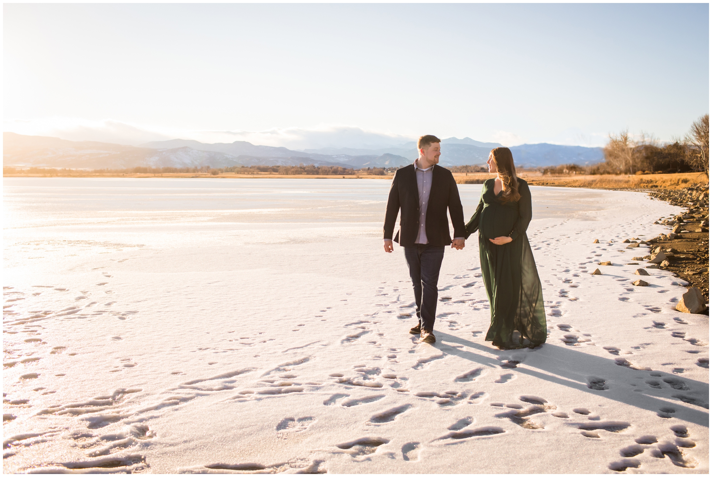 couple walking on frozen lake during Longmont Colorado winter maternity photography session