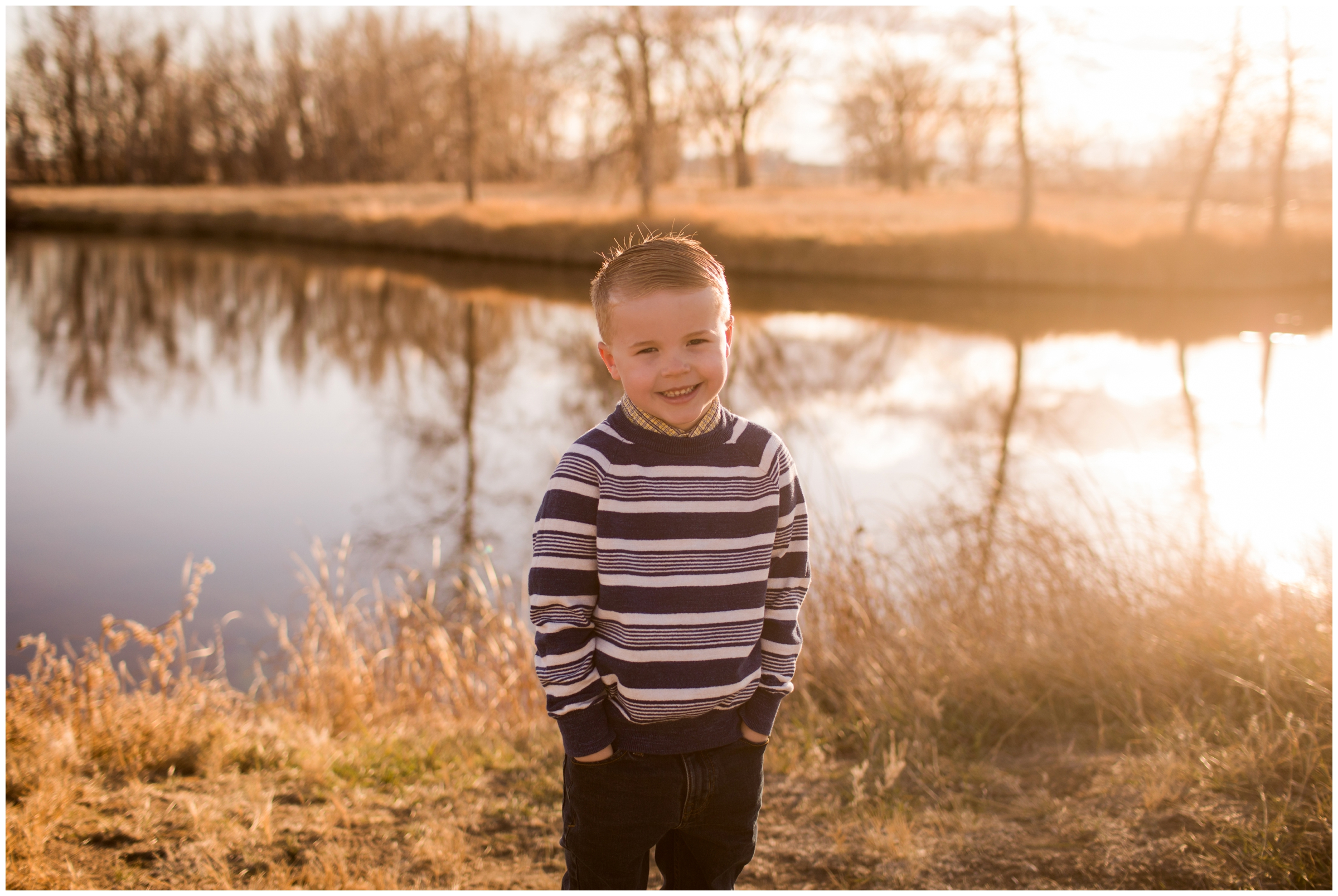 little boy posing in front of pond during Colorado fall family photography session 