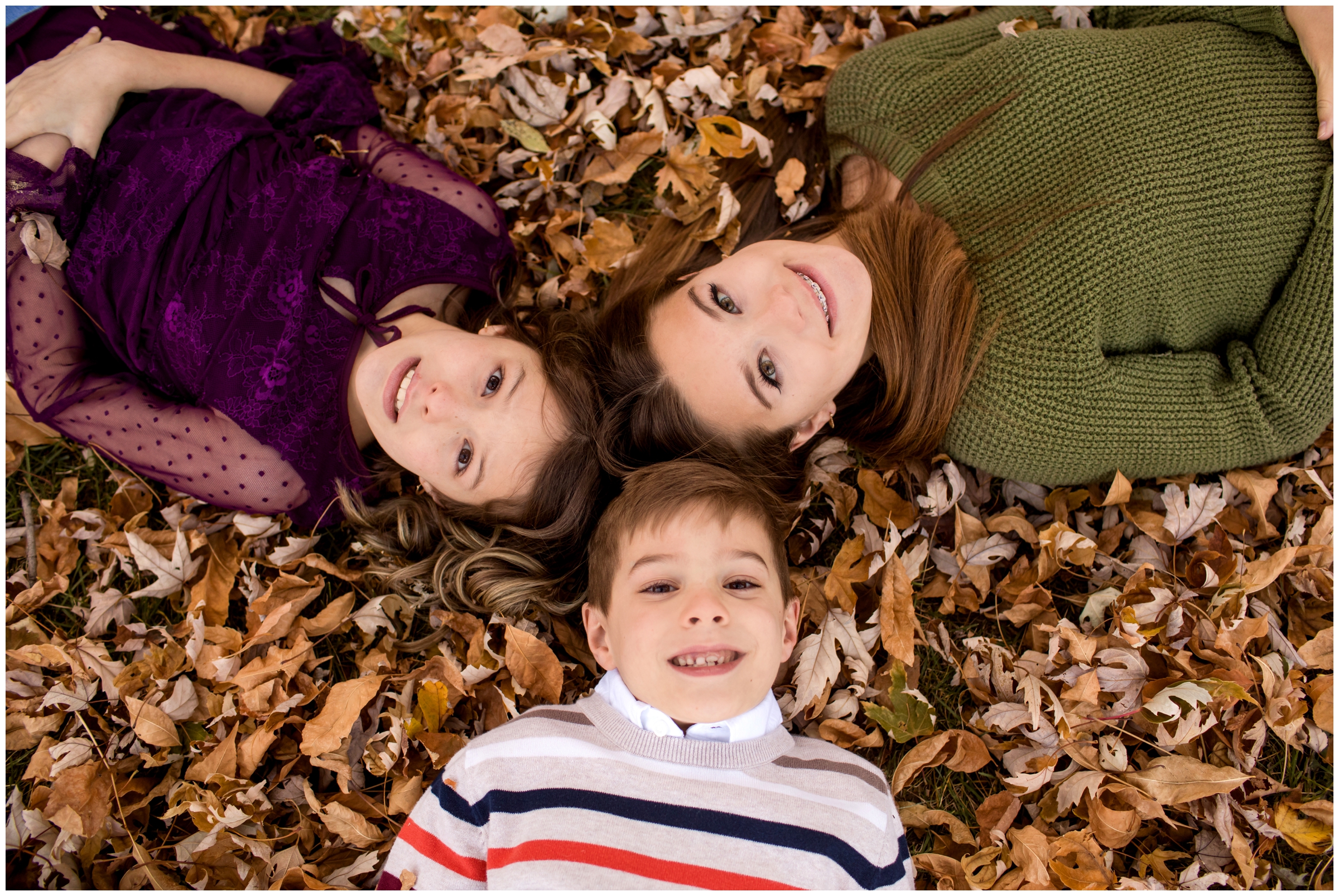 kids laying in leaves during Lyons Colorado fall family pictures 