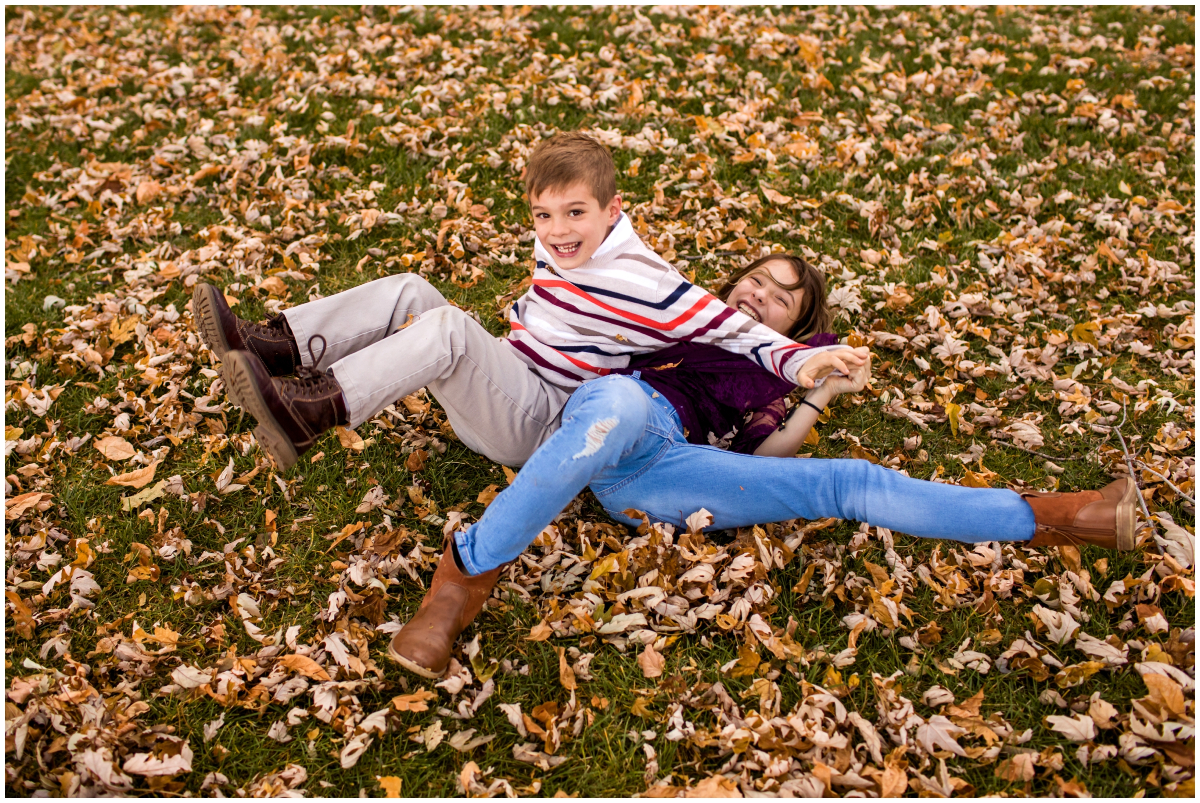 siblings wrestling in leaves at Lavern m johnson park Colorado 