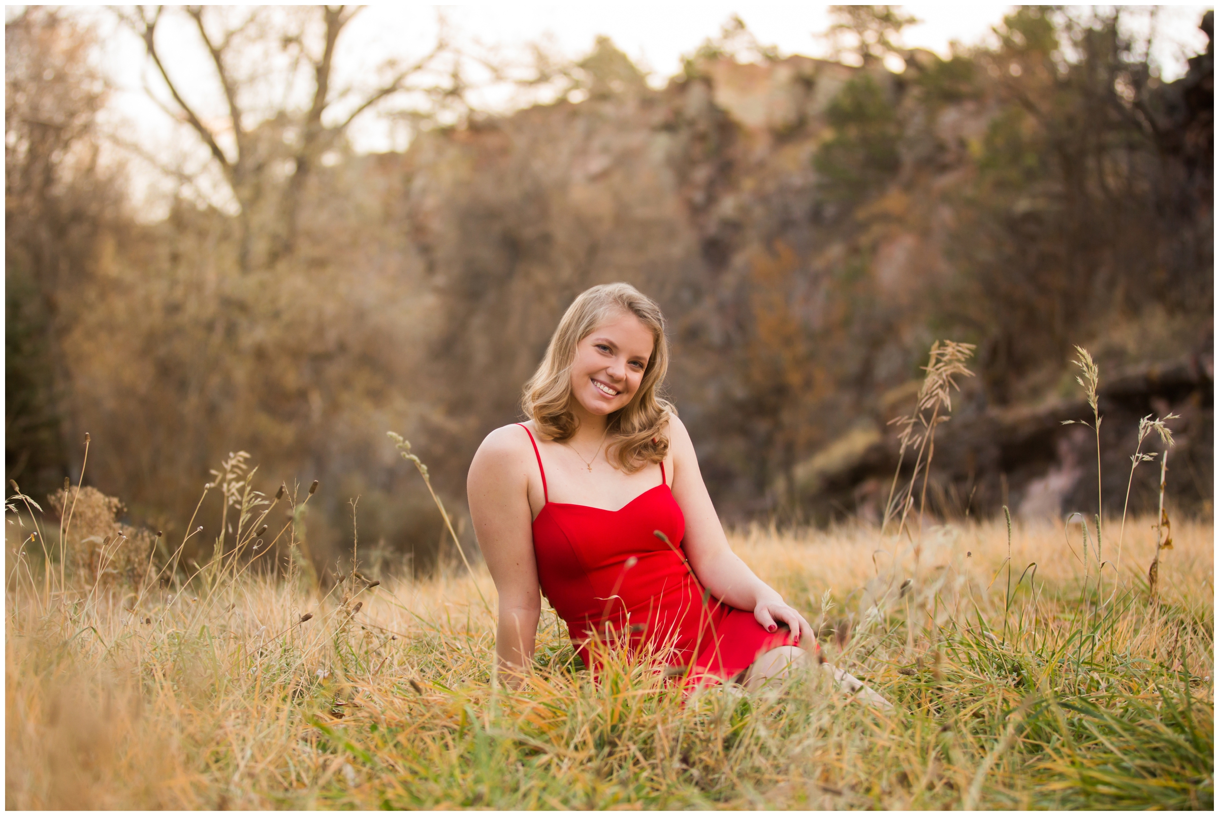 teen sitting in a field during fall senior photos in Lyons Colorado 