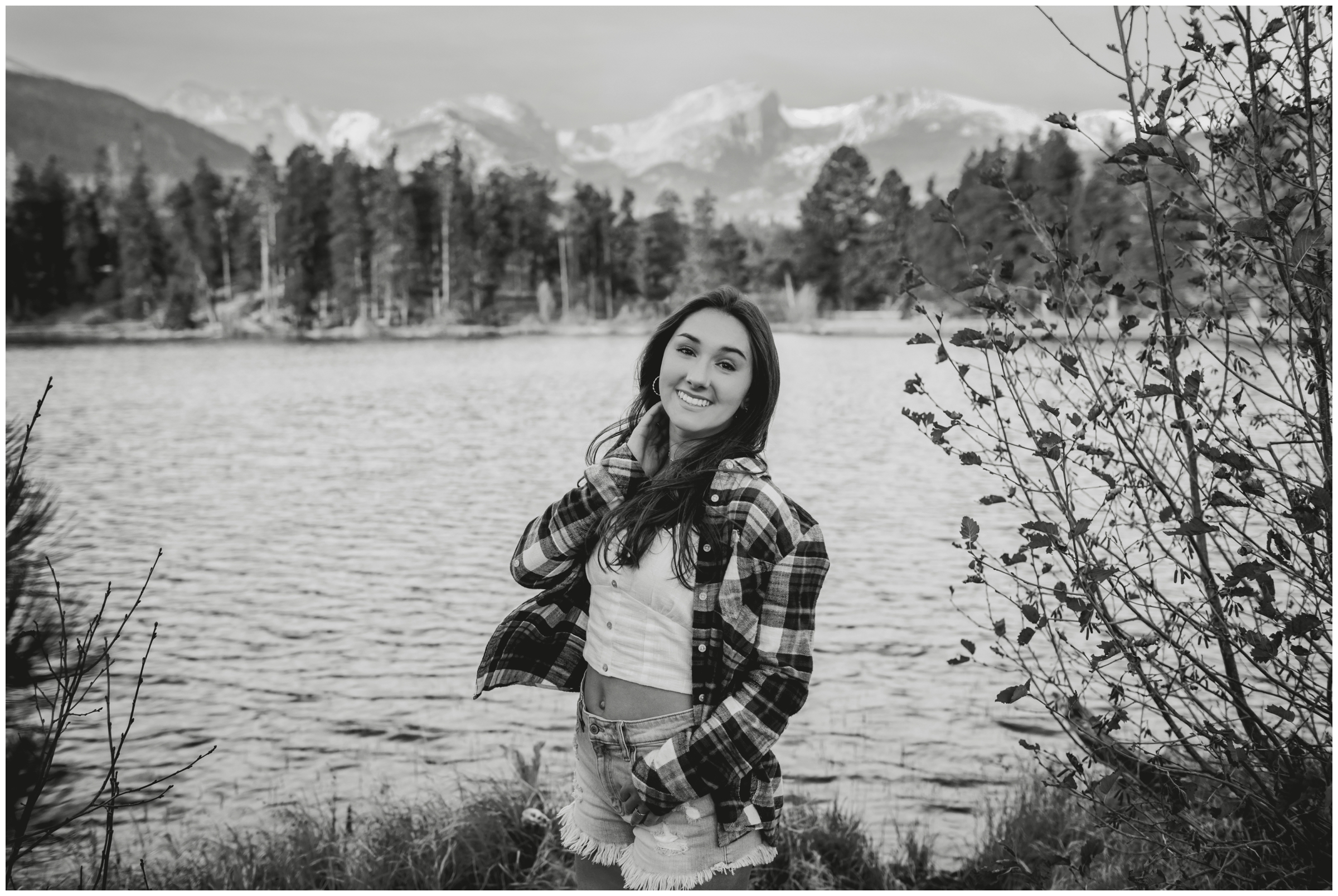 girl posing with mountains and lake in background during RMNP senior portraits 