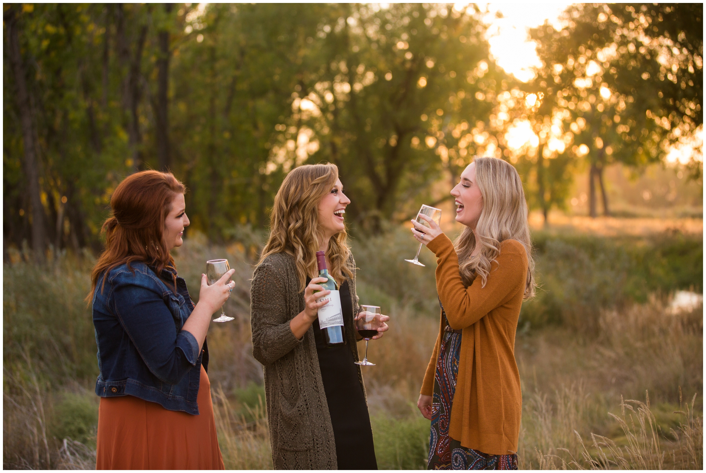 women friends drinking wine and laughing during Colorado photo shoot 
