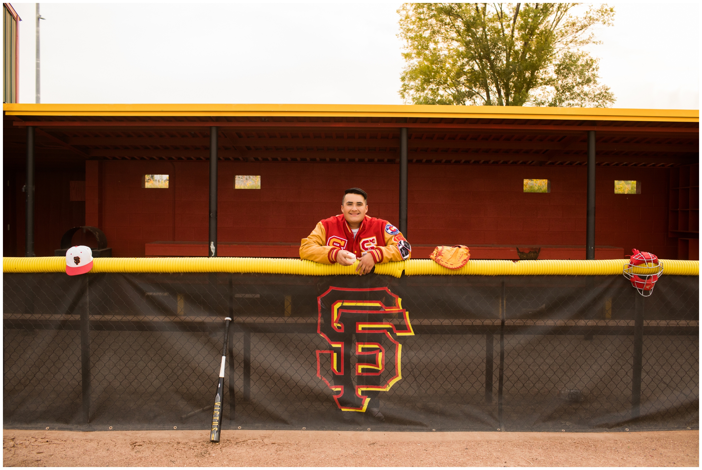 Teen boy posing in dugout during baseball senior photography session in Longmont Colorado 