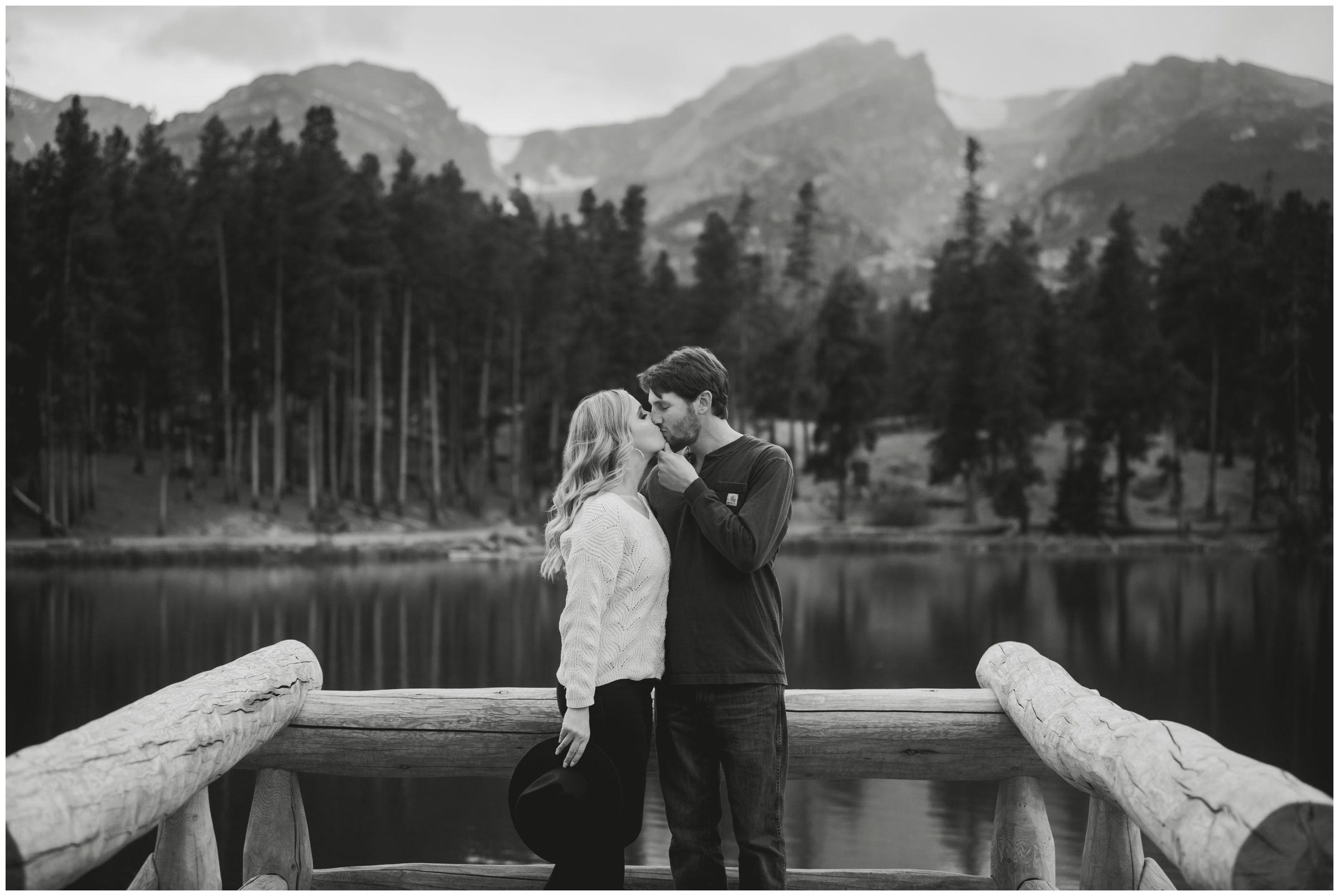 couple kissing on dock during Colorado lake engagement photography session 