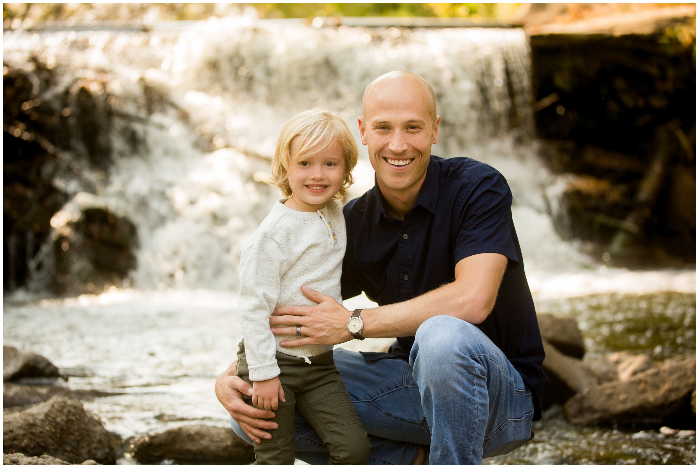dad and son posing by waterfall at Colorado fall family photo session