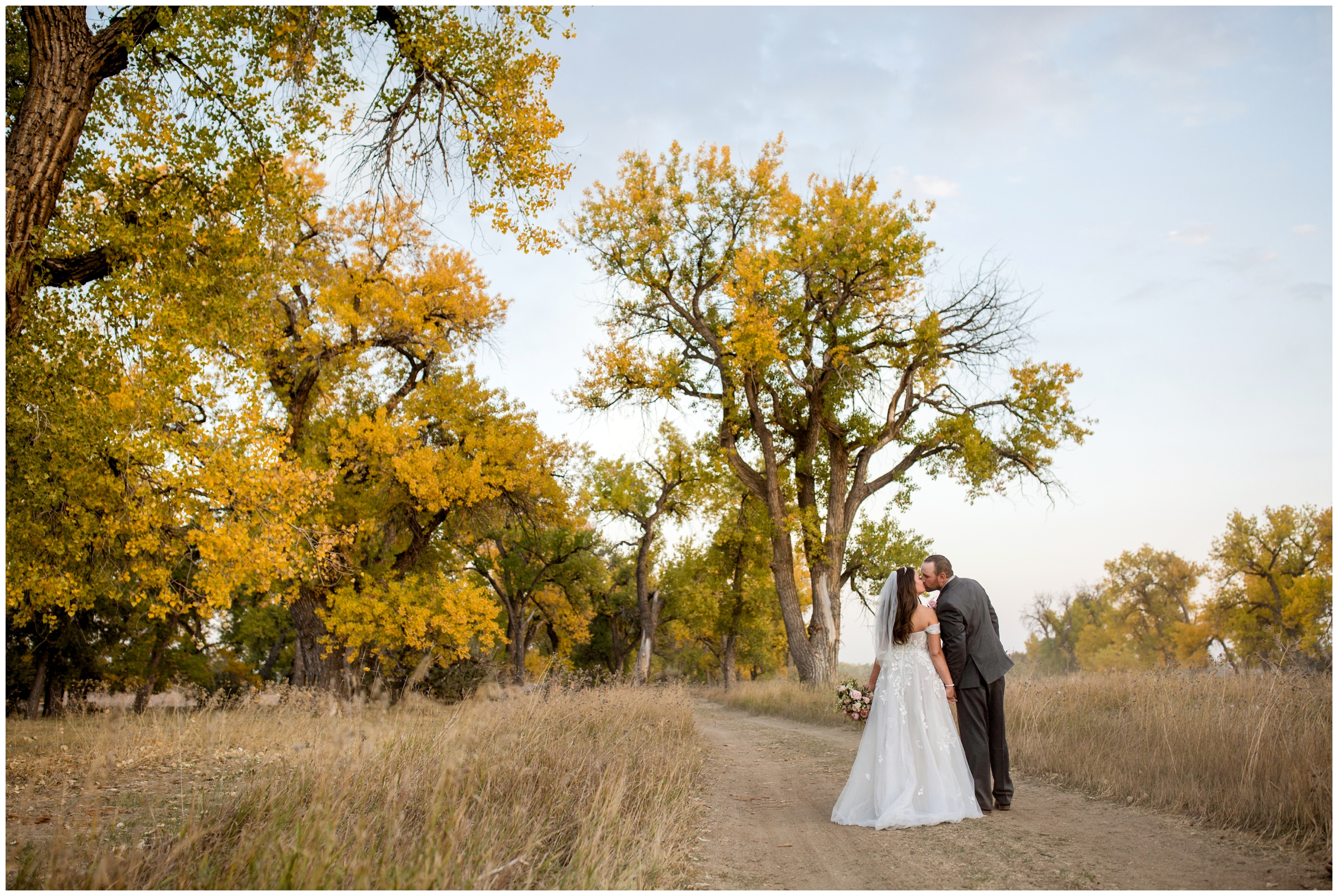 couple kissing on dirt road during rustic Colorado wedding pictures 