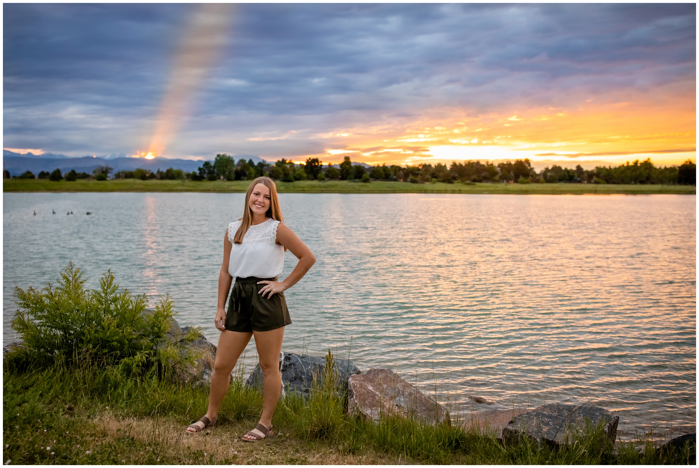 Teen girl posing by a lake during sunset senior pictures in boulder Colorado