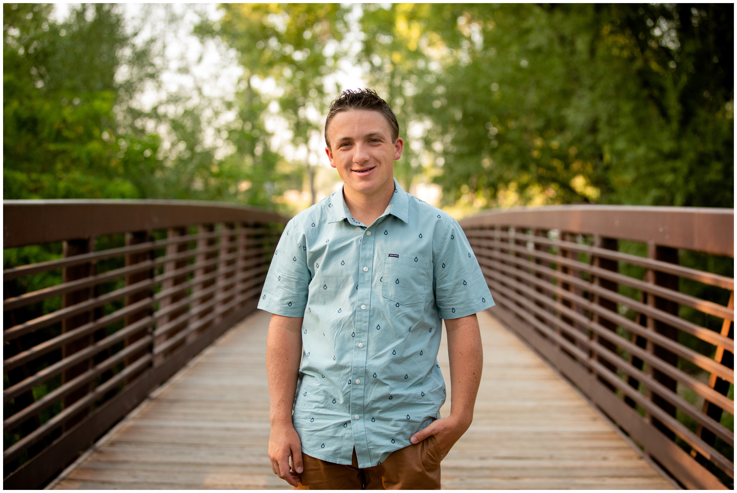 teen guy posing on bridge during Longmont senior photography session 