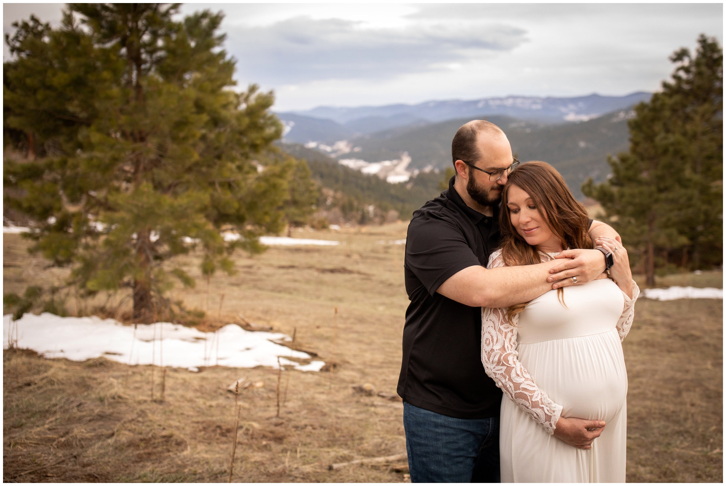 Couple embracing during spring maternity pictures in the Colorado mountains 