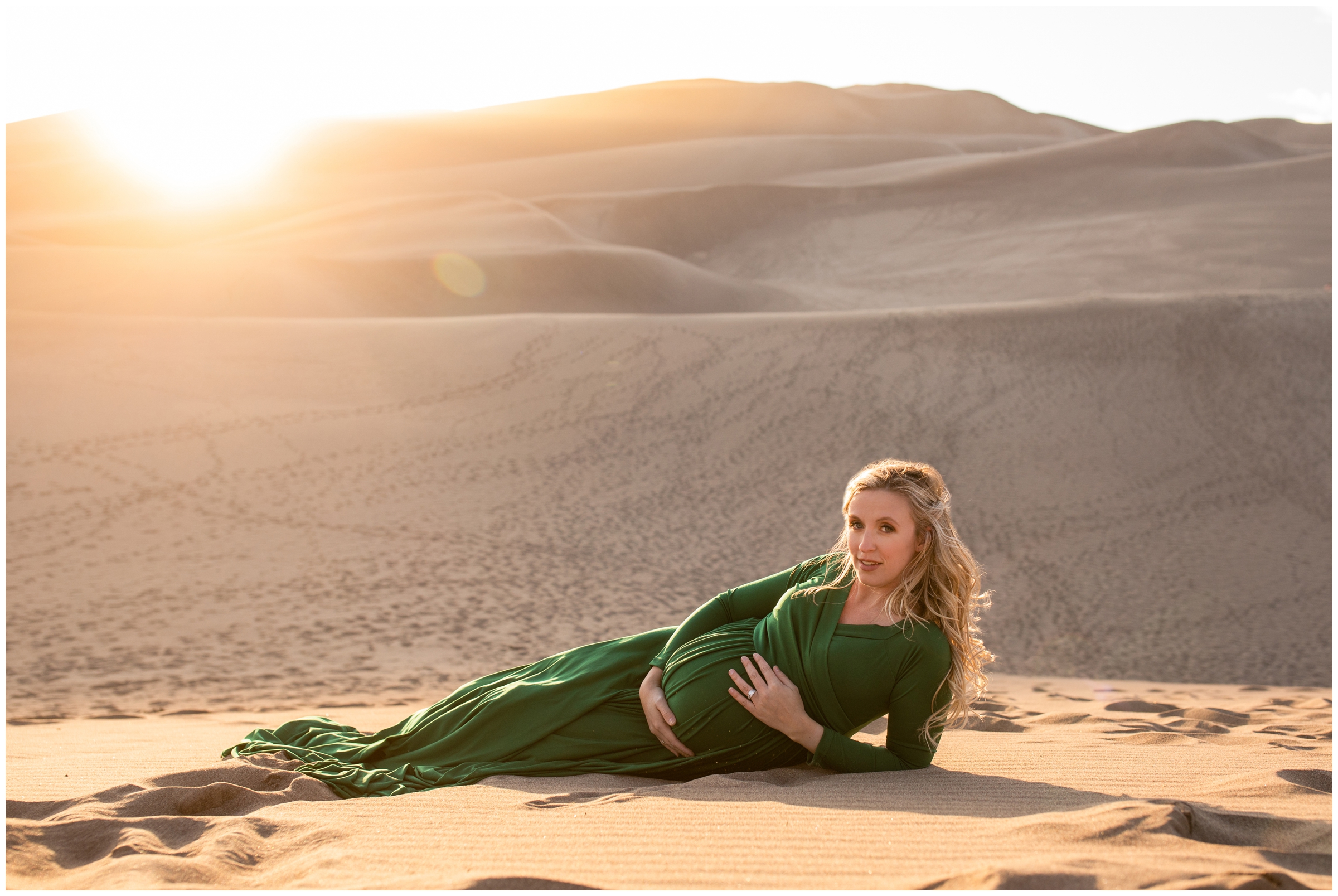 woman laying in the sand during CO pregnancy photo shoot
