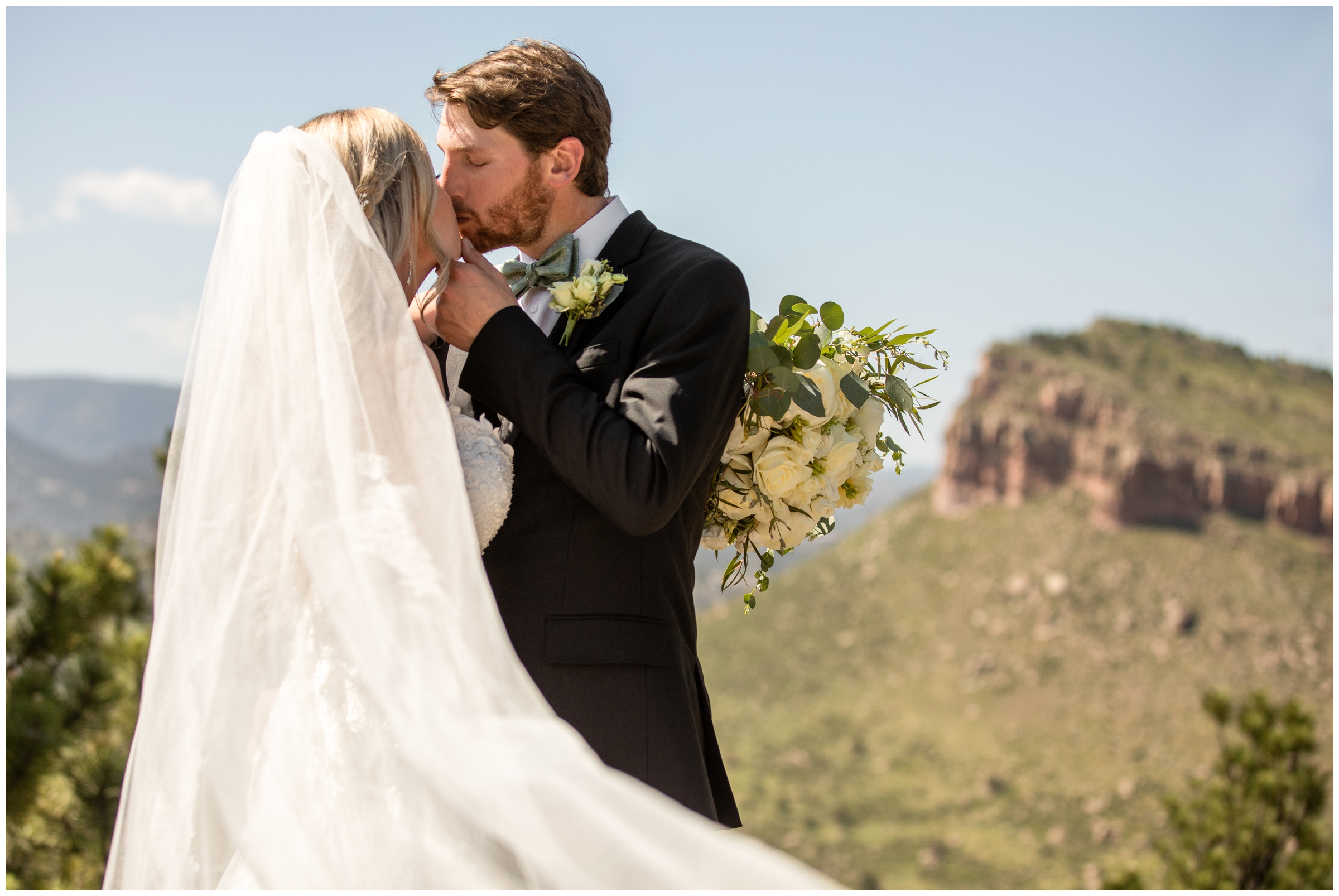couple kissing on top of mountain during their Lionscrest Manor summer wedding pictures 