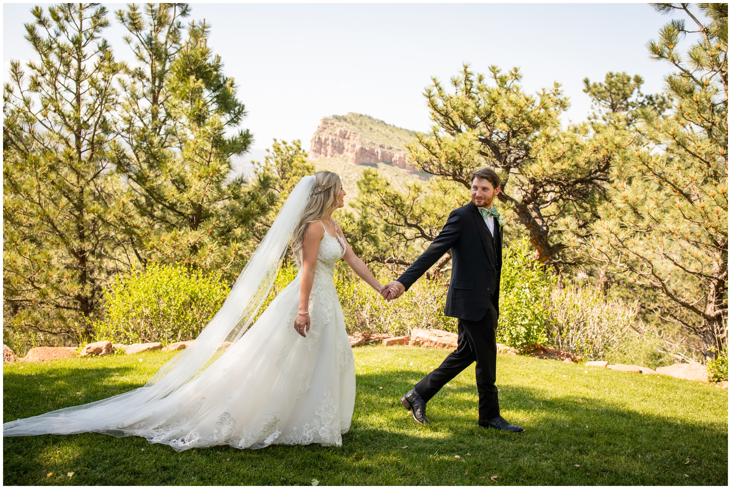 bride and groom walking with mountains in background during Lyons Colorado wedding photos 