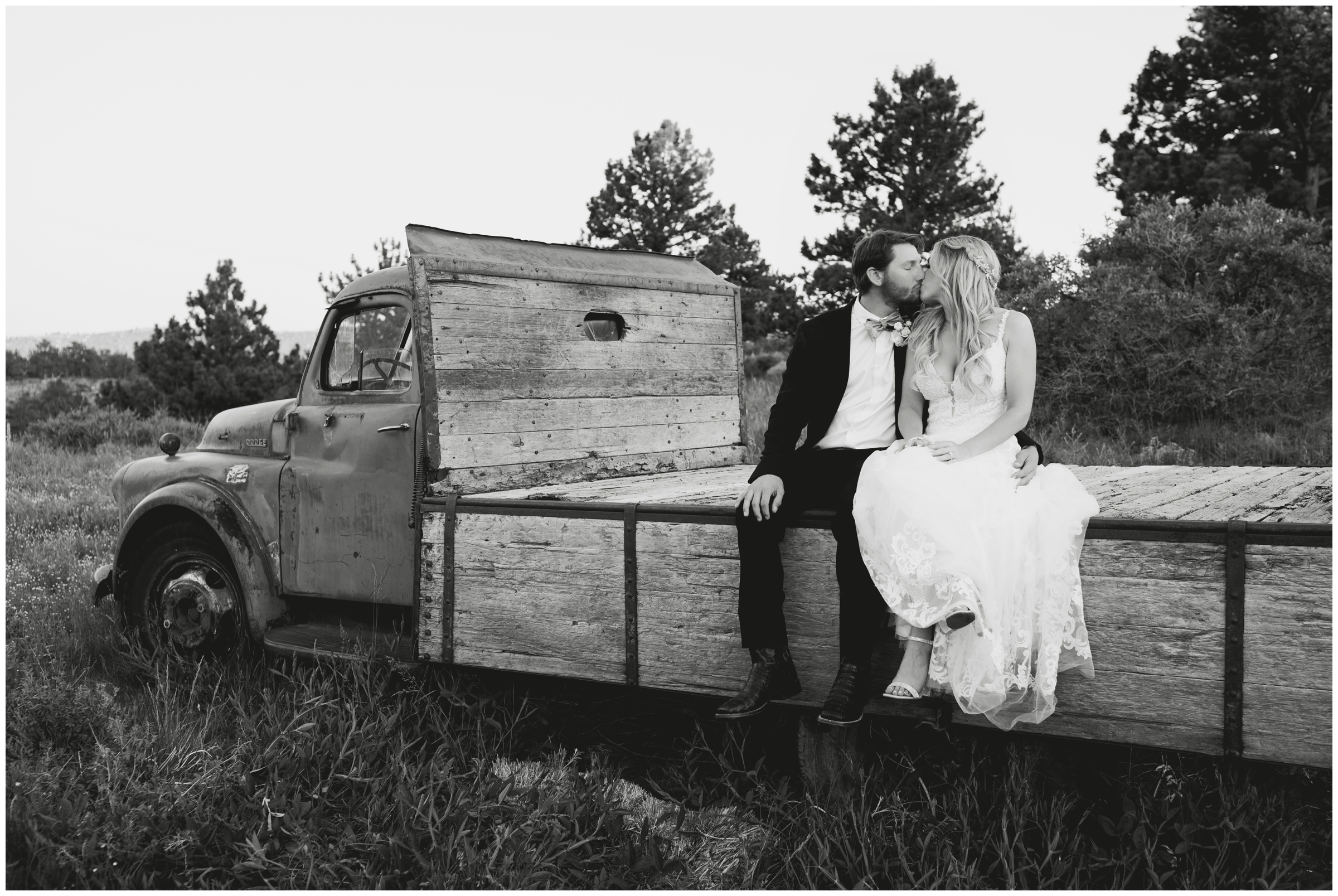couple sitting on truck bed of old farm truck at Lionscrest Manor in Lyons Colorado during golden hour wedding portraits