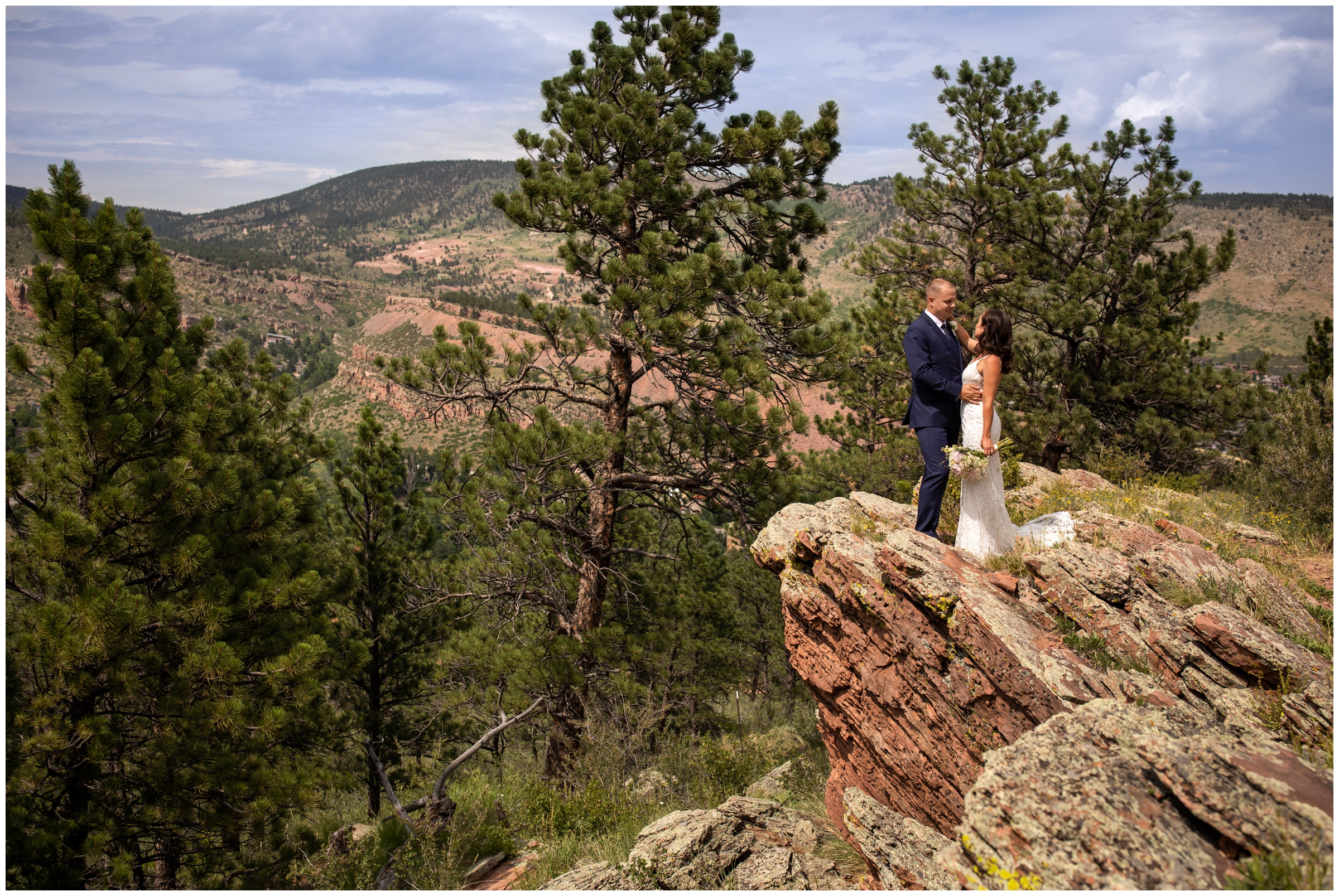 Couple posing on edge of cliff during Colorado mountain wedding photography at Lionscrest manor 