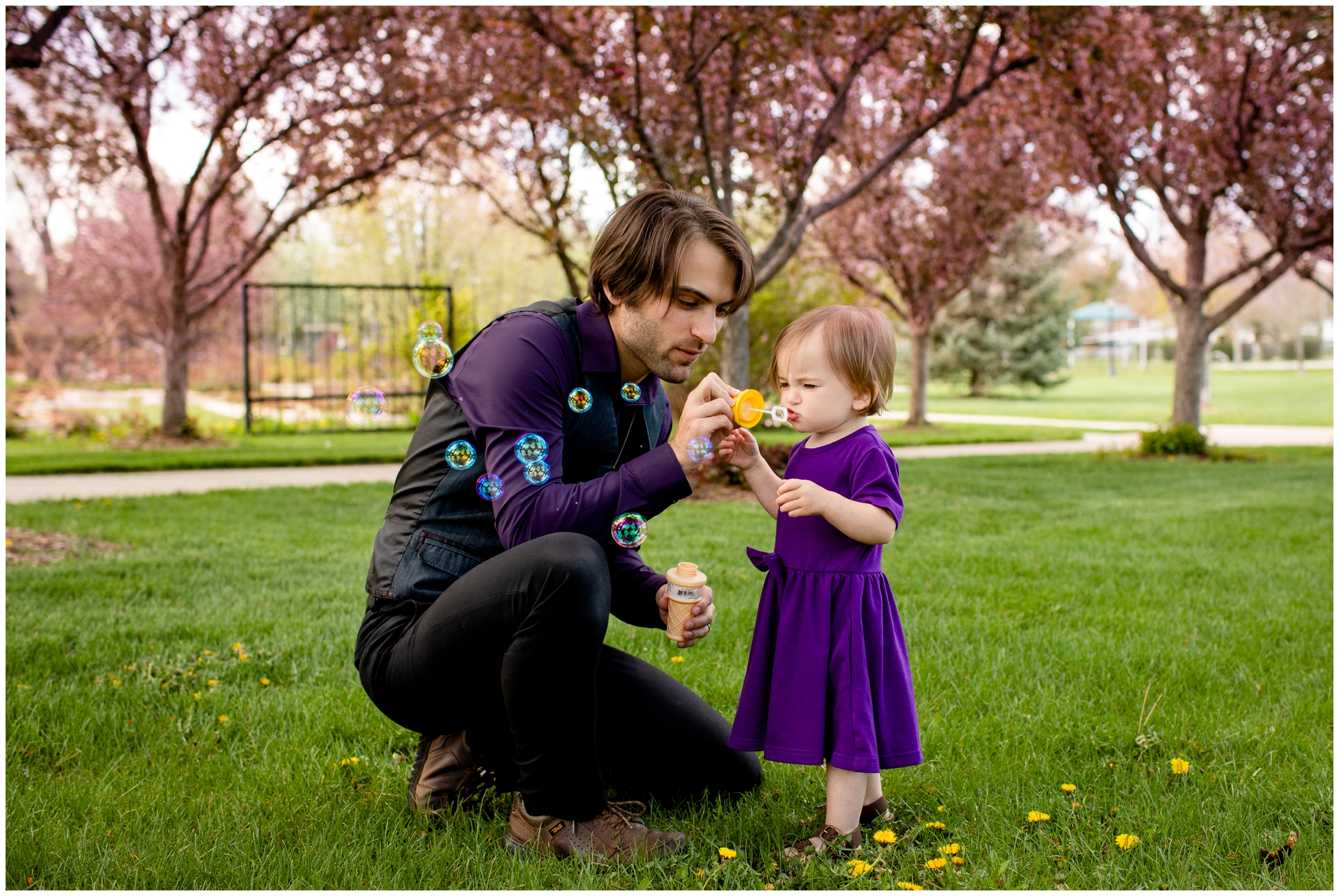 little girl and her dad blowing bubbles during candid Colorado family photography session 