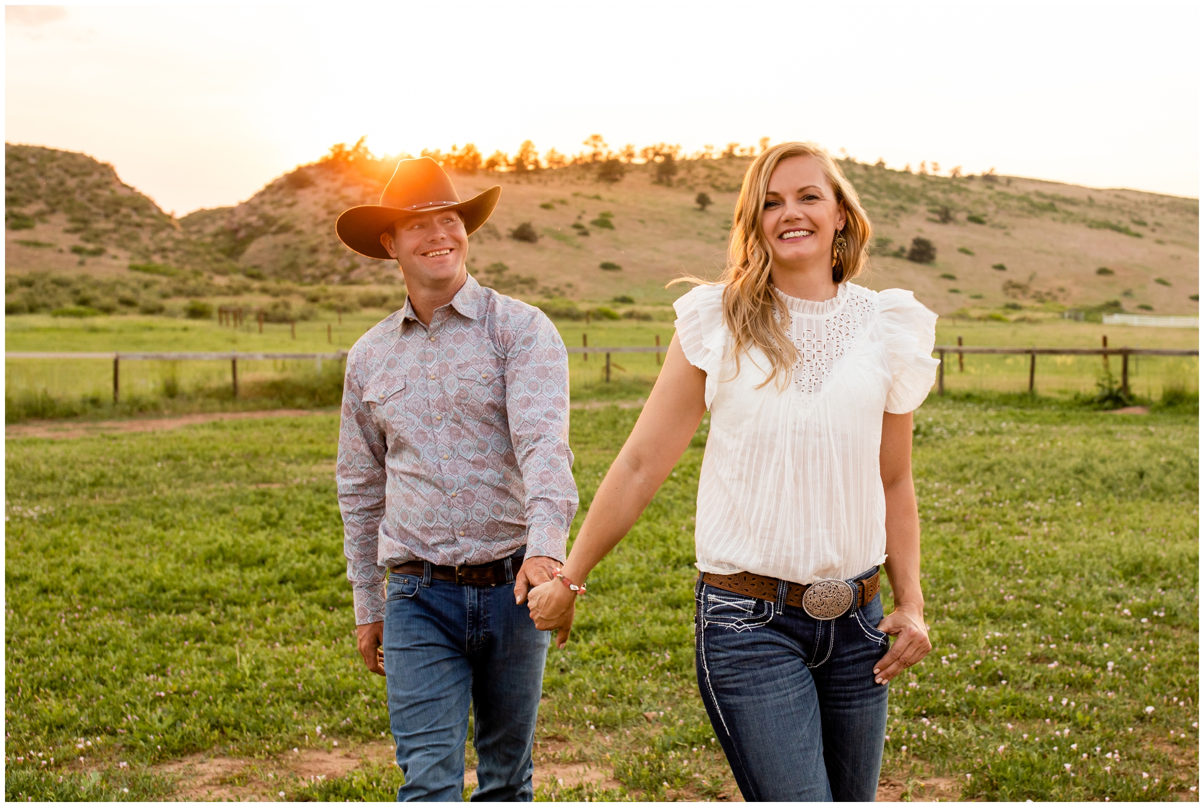 Rustic country couple holding hands and walking through farm field during Loveland CO engagement pictures 