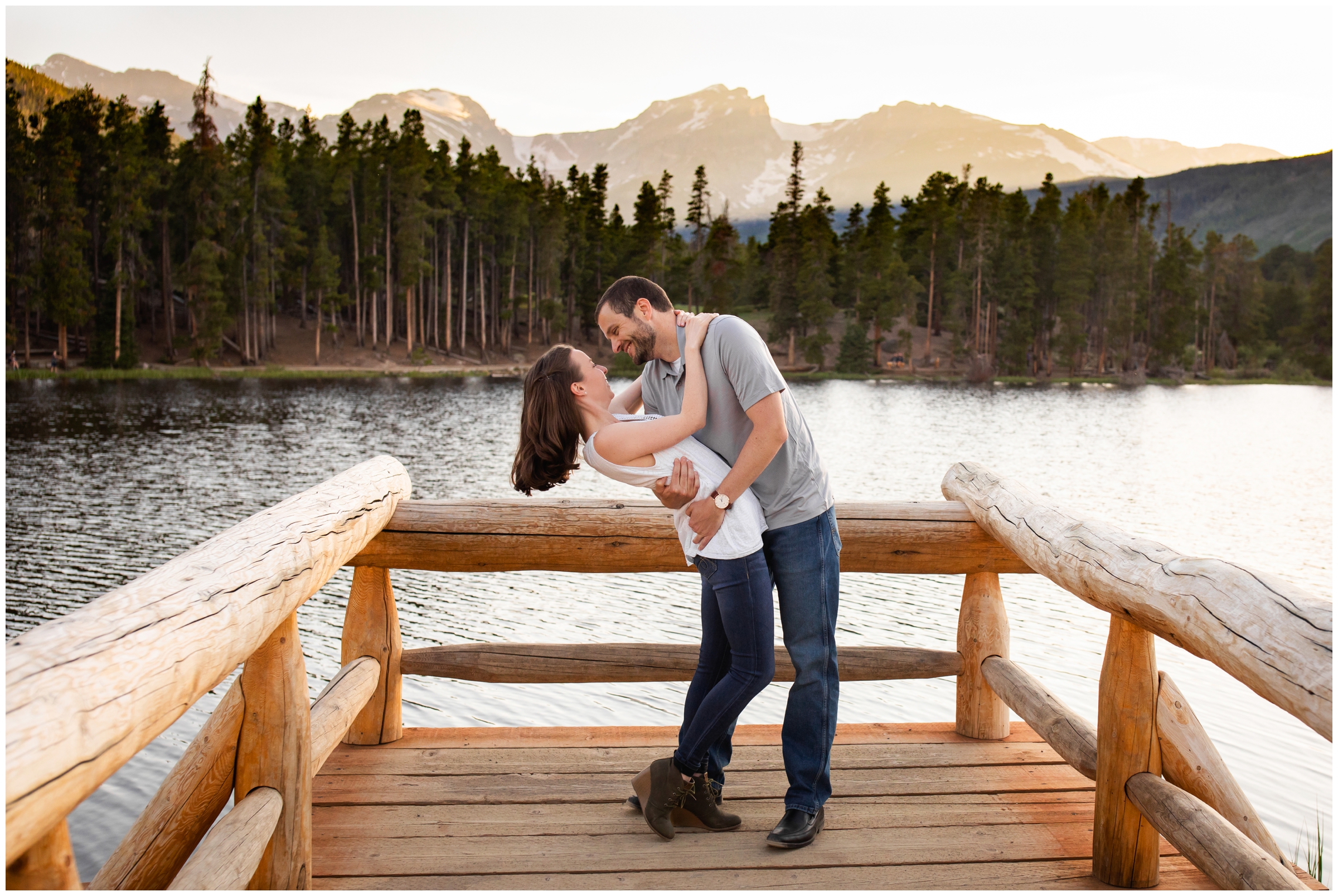 man dipping fiancé on a dock during colorado lake engagement pictures in RMNP