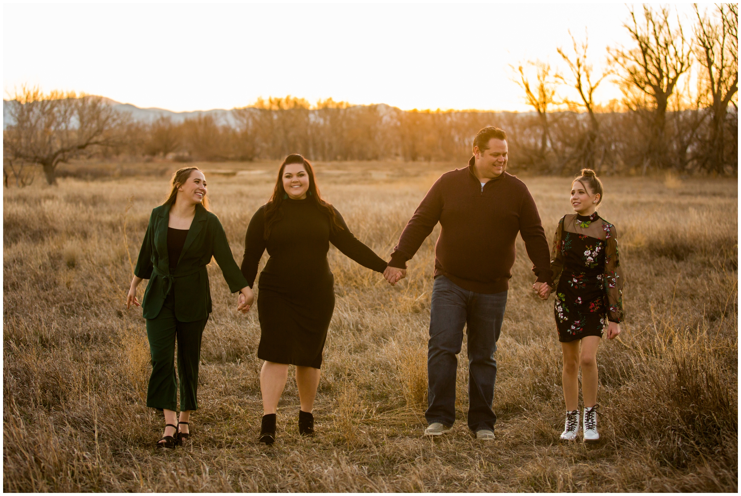 family holding hands and walking in a field during Longmont Colorado photography session at Sandstone Ranch 