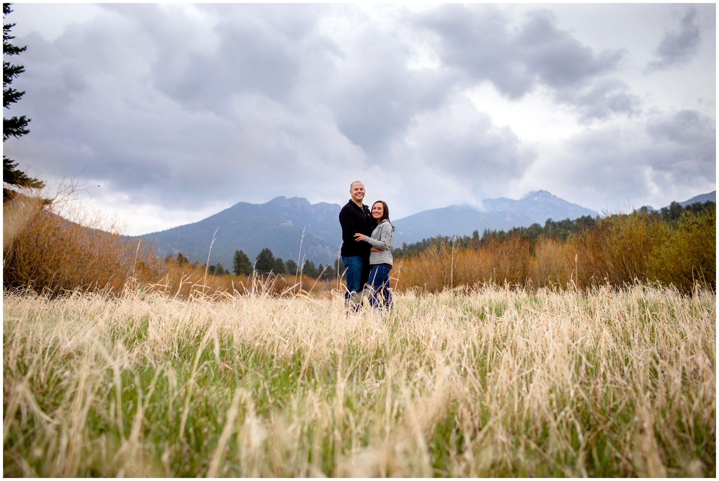 Couple posing in field of long grasses during Colorado mountain engagement portraits 