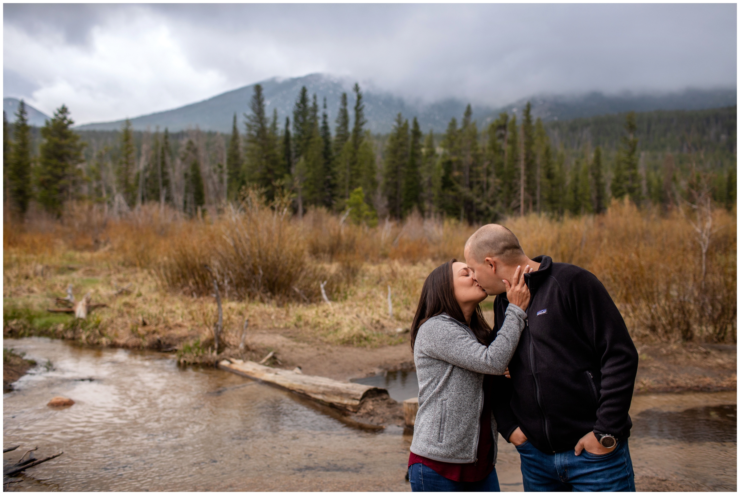 Couple kissing during river engagement photos in estes park Colorado 
