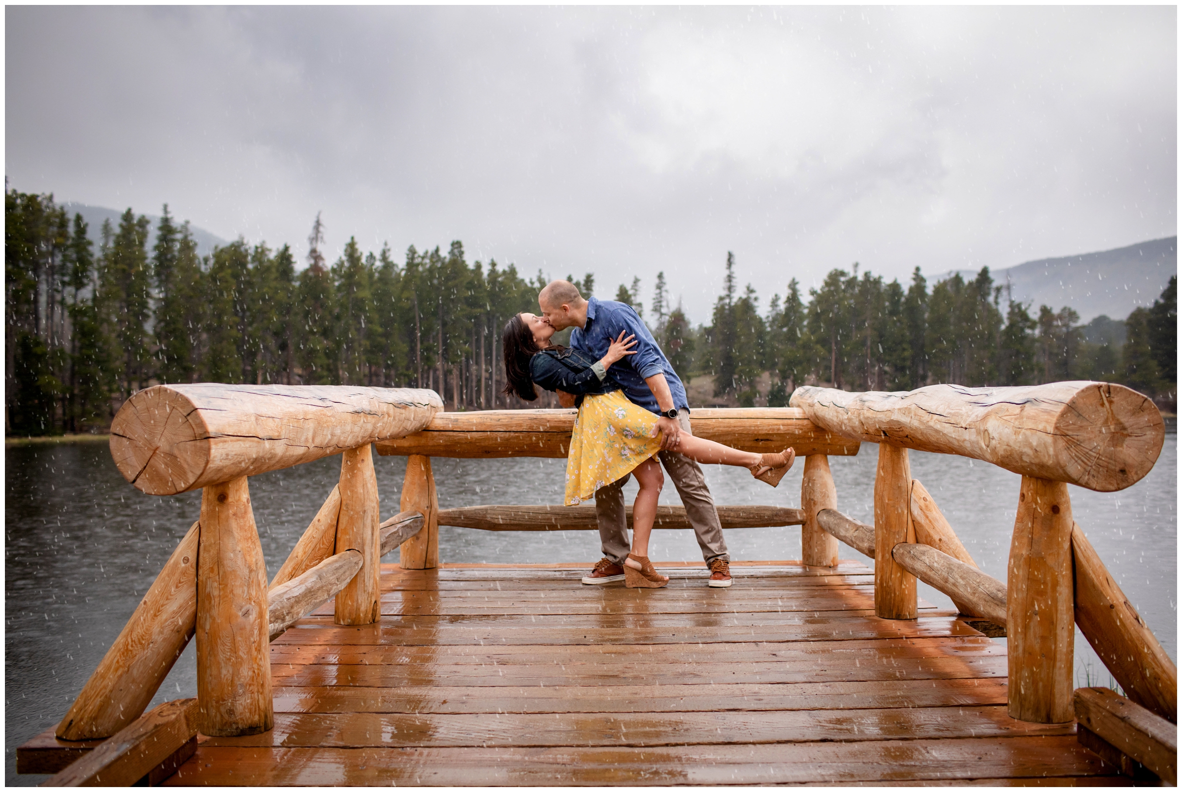 Guy dipping fiancé on dock during rainy RMNP estes park engagement photos 
