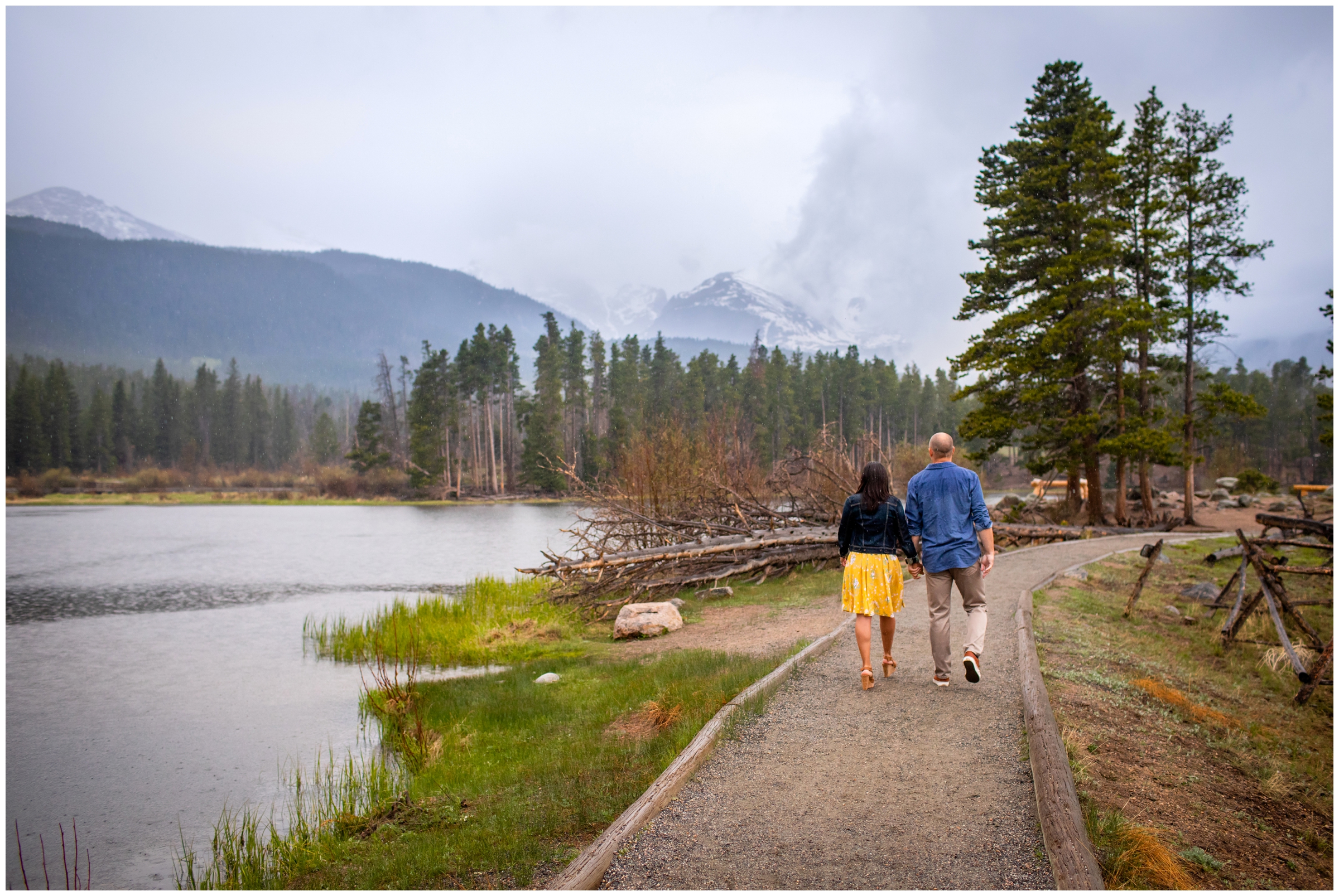 Couple walking in the rain during RMNP engagement pictures at Sprague Lake 