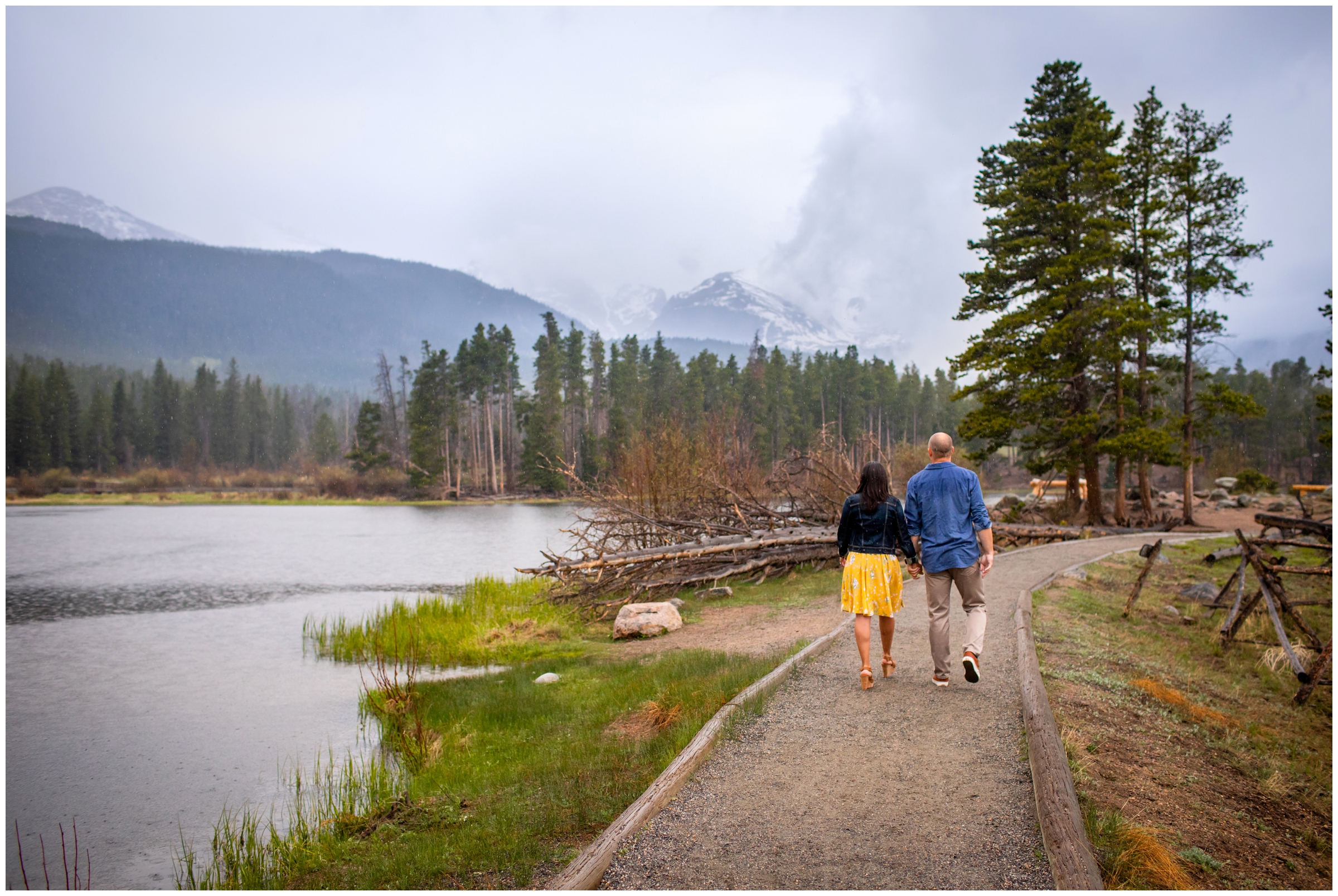 Couple walking in the rain during RMNP engagement pictures at Sprague Lake