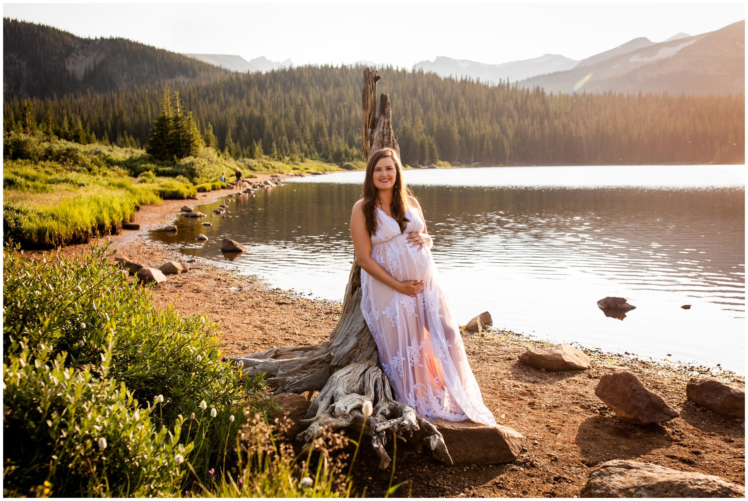 woman leaning against driftwood during mountain maternity portraits at Brainard lake Colorado 