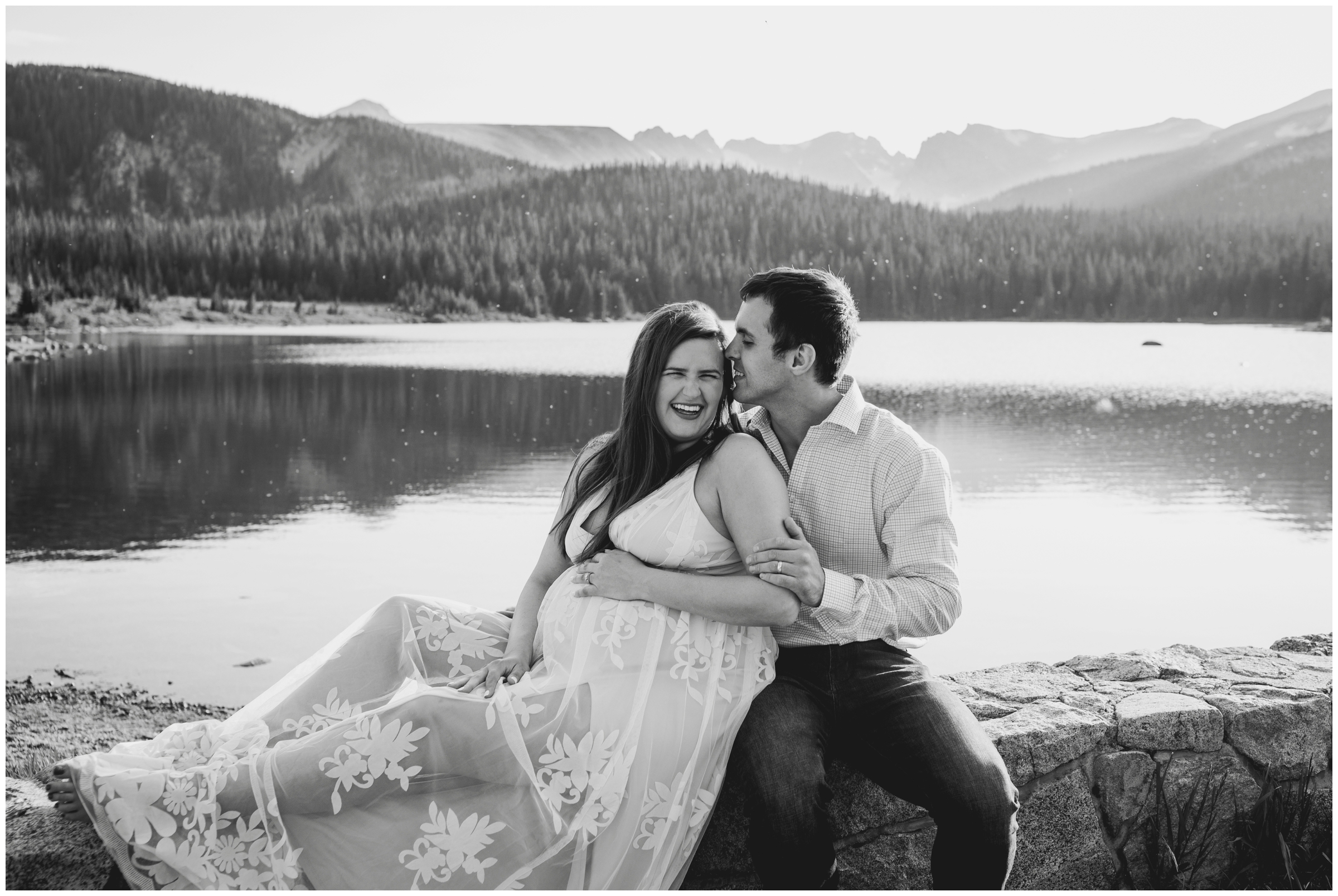couple sitting on stone bridge during a maternity photography session in the Colorado mountains 