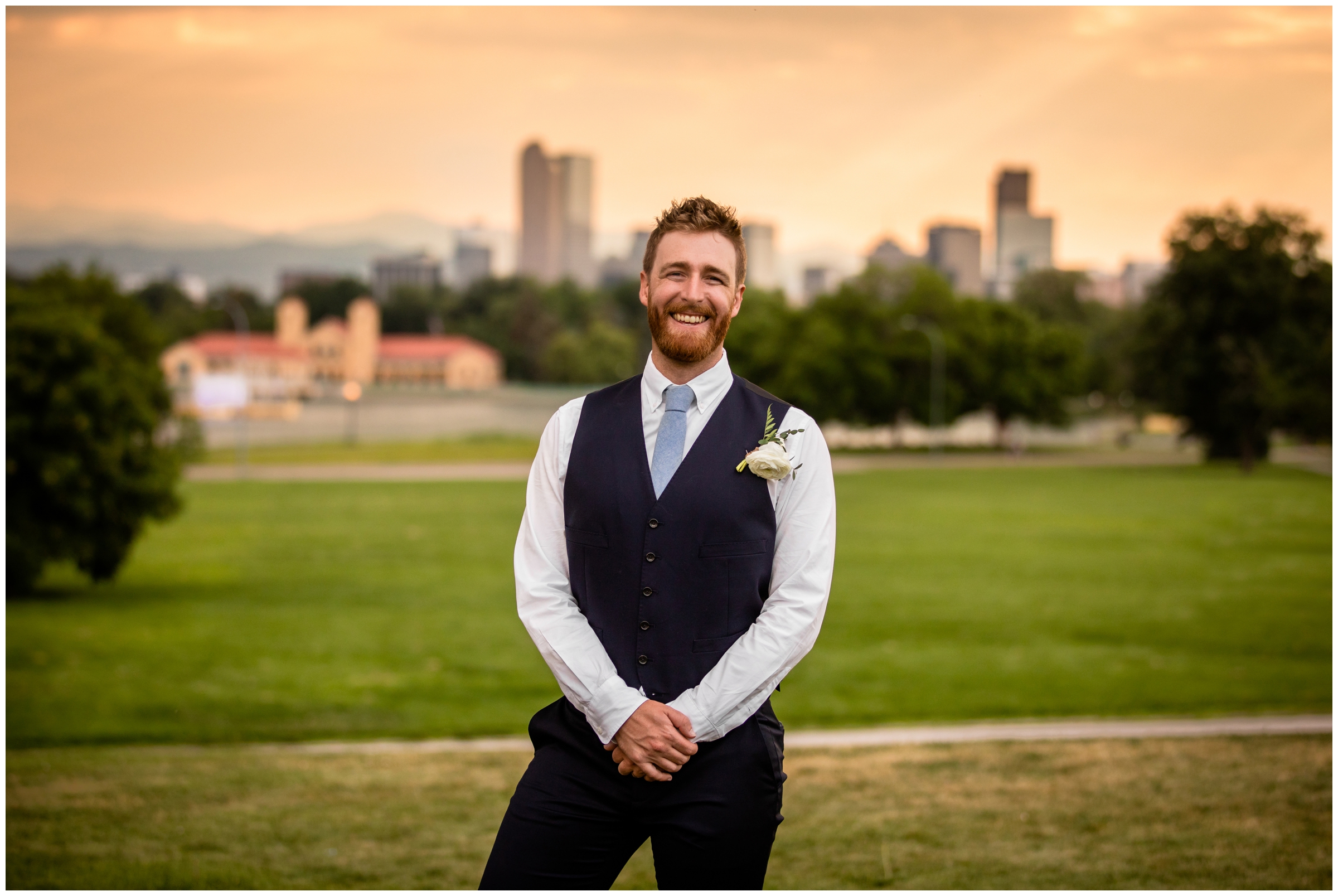 groom posing at sunset with Denver skyline in the background 