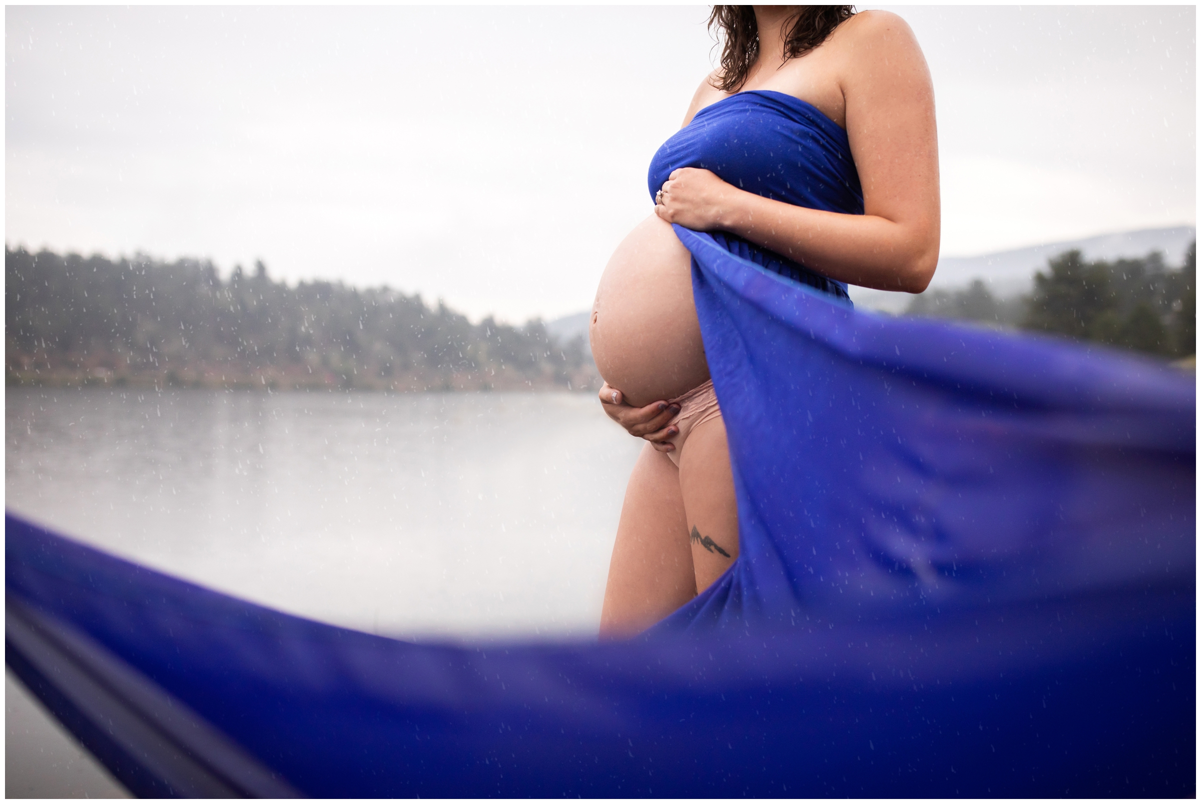 woman in royal blue Sew Trendy maternity gown during Colorado lake maternity photography session in Evergreen 