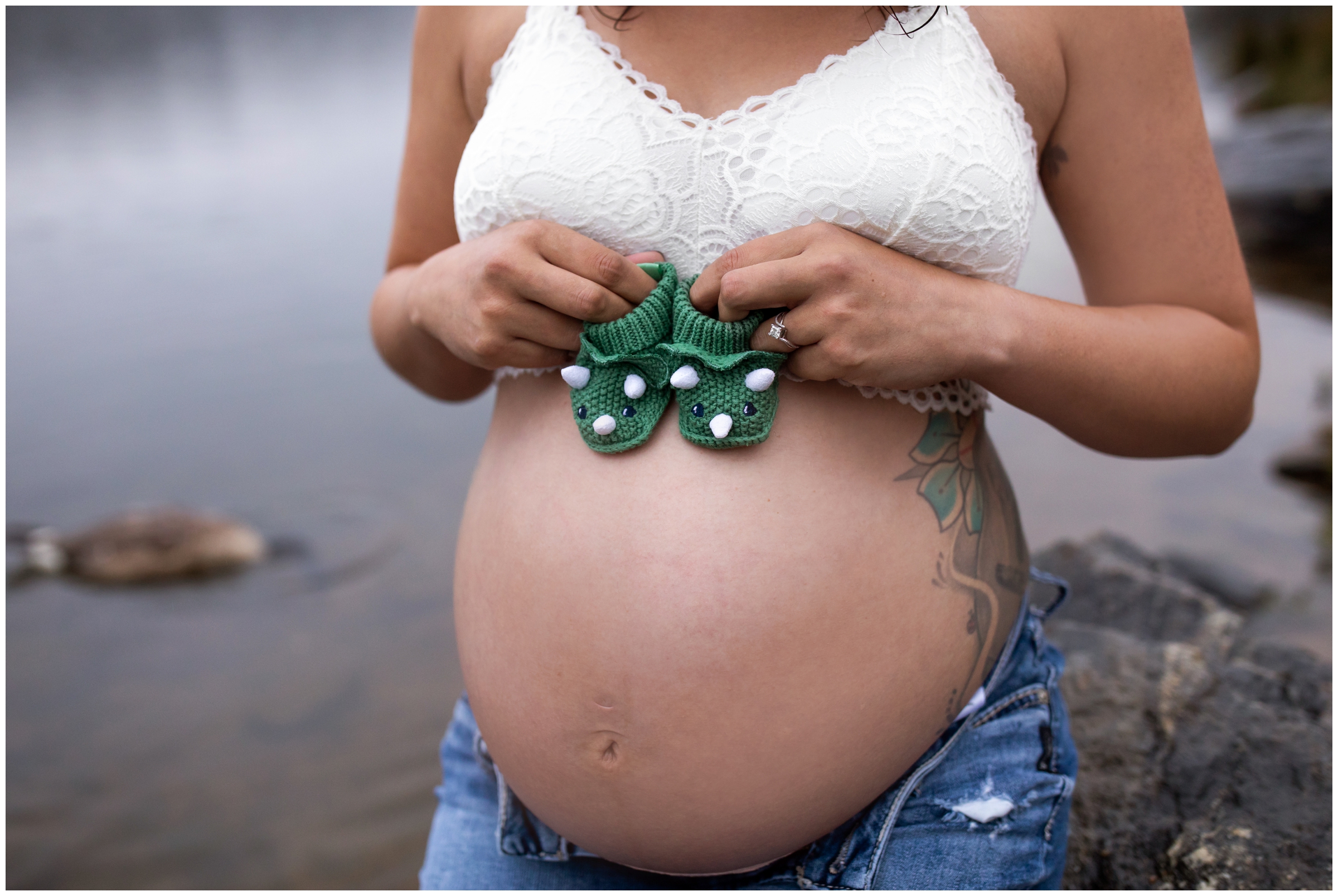 woman holding baby booties on belly during CO pregnancy portraits 