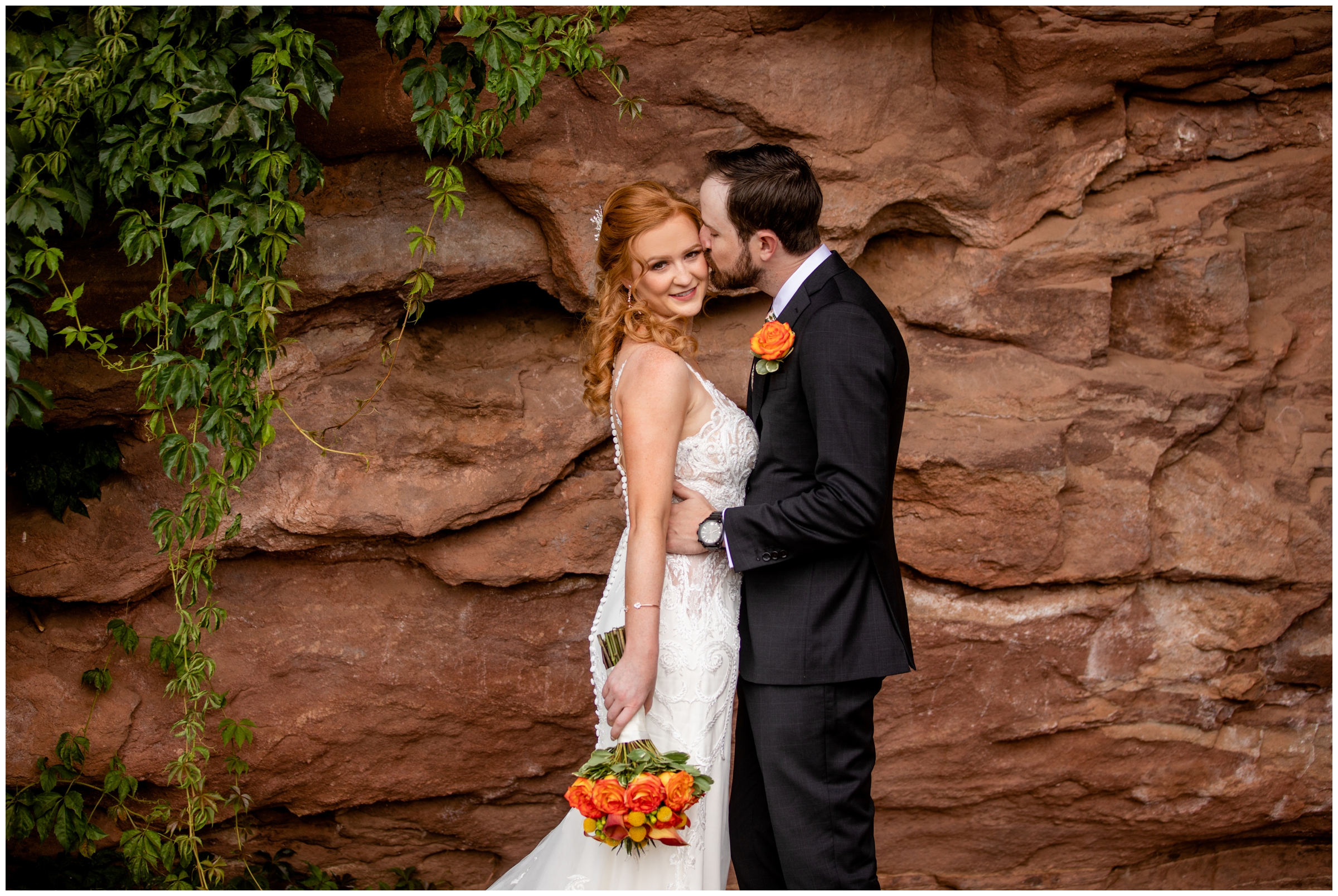 groom kissing bride with red rocks in background before Solterra Colorado wedding 