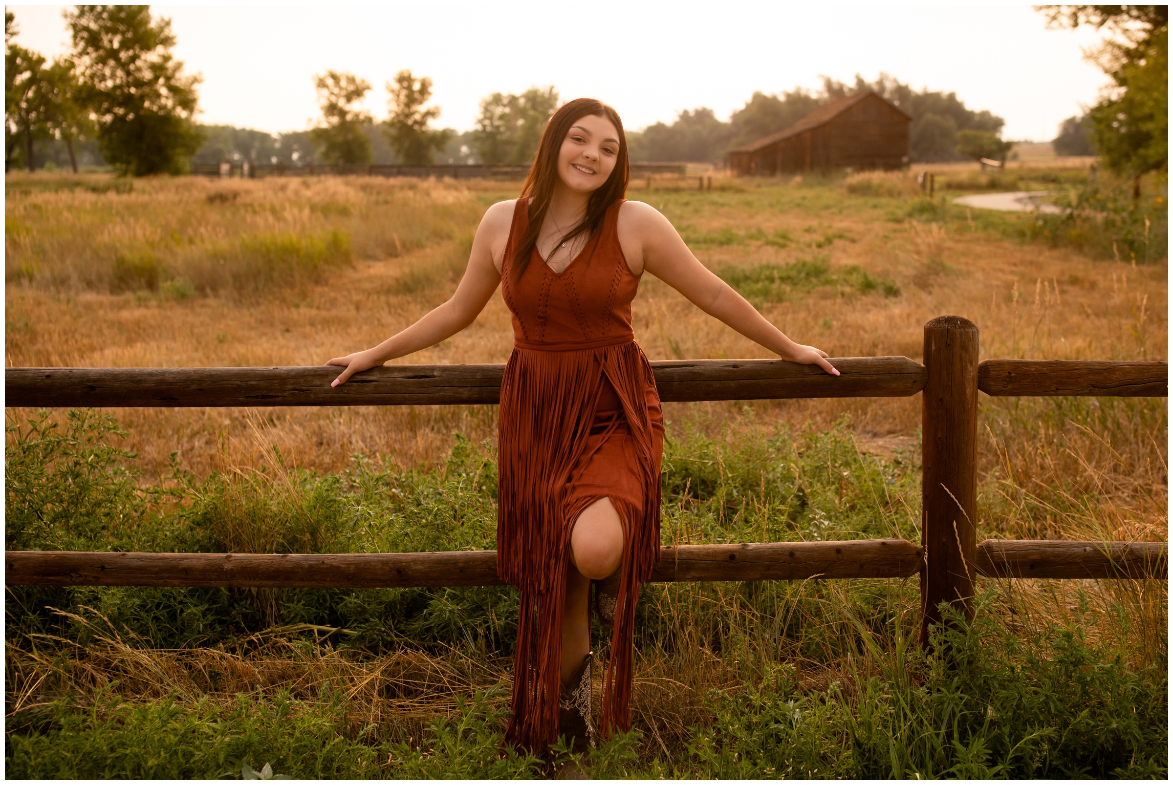 teen leaning against fence during rustic ranch senior portraits in Longmont 