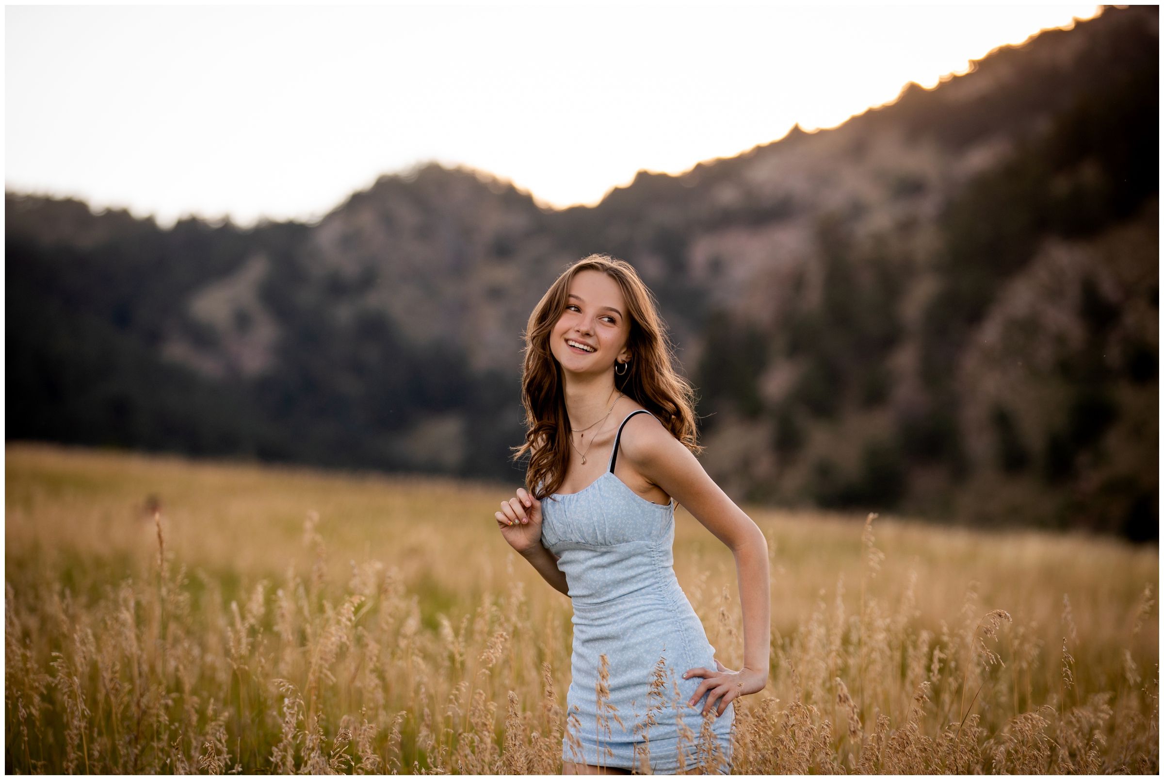 teen posing in field of long grasses during Colorado mountain senior photography session by Plum Pretty Photos